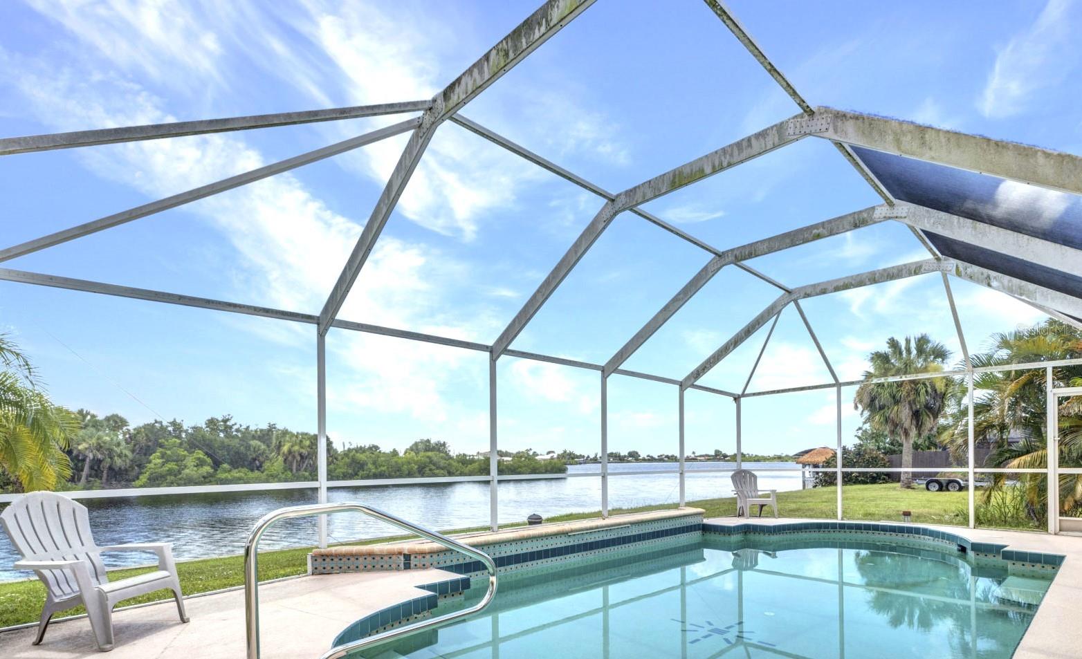 AMAZING WATERFRONT VIEWS From this delightful 3/2/2 home on Spring Lake- enjoy boating from your backyard! Only 15 minutes and one bridge to open water! Open floor plan with cathedral ceilings provides a spacious feel. Currently decorated with an airy, Southwestern motif. Split plan affords privacy to the primary bedroom. Lovely heated pool in back Lanai for enjoying a dip and taking in the views all year long! Well maintained, only one owner. Minutes to all shopping, beach and amenities. Enjoy breakfast in the dinette or out on the Lanai, with views of the sunrise over the lake! Undeveloped island view with scenes of local wildlife; birding, fishing from your back yard. Make this your tropical paradise home! Room measurements deemed accurate but not guaranteed. Please provide proof of funds or approval letter with any offers.