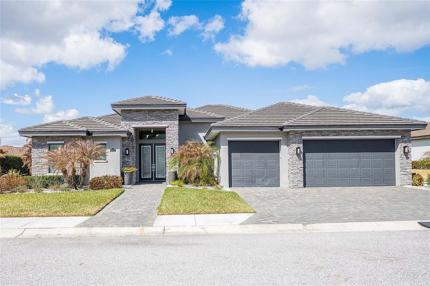 Positioned Within The Heritage Lakes Enclave Of Grasslands Golf & Country Club And Secured Behind 24-Hour Guard Gates, This 2021 AR Homes By Arthur Rutenberg Residence Reflects Quiet Refinement And Thoughtful Design.
Offering 3 Bedrooms, 3 Full Baths (Including 2 Ensuite), Plus A 16’x14’ Flex Office With Double-Door Entry, The Thoughtfully Designed Triple Split Floor Plan Provides Ideal Separation And Privacy For Guests Or Multi-Generational Living, While Maintaining Seamless Flow For Daily Life And Entertaining.
Set On A Fenced .27-Acre Homesite With Water Views, The Home Showcases Clean Architectural Lines, Tray Ceilings, Crown Moulding, Seamless Tile Flooring, And A Clean Modern Palette. Custom Designer Wallpaper, Motorized Blinds, And Integrated Accent Lighting Elevate The Interior With Understated Sophistication.
The Open-Concept Kitchen Is Designed For Both Function And Gathering, Featuring Custom Cabinetry, Quartz Surfaces, Wall Oven, And An Oversized Hidden Walk-In Pantry. Overlooking The Main Living Space And Extending Sight-lines To The Outdoor Lanai And Water Views, It Creates A Natural Hub For Entertaining.
The Primary Suite Serves As A Private Retreat, Highlighted By A Spa-Inspired Bath Featuring A Frameless Glass Shower With Dual Shower Heads, An Empava Massage Soaking Tub, And An Expansive 18’x13’ Walk-In Closet.
Outdoors, A 32’x23’ Screened Lanai With Paver Extension Overlooks Tranquil Water Views — Ideal For Relaxed Evenings Or Quiet Mornings.
Grasslands Is Anchored By An 18-Hole, Par-72 Championship Golf Course Designed By Jerry Pate And Bob Cupp. Built On Central Florida Sand Scrub, It Offers A Distinctive Inland Links-Style Experience With Open Sight-Lines And Strategic Play. Club Membership Is Optional And Available Separately.