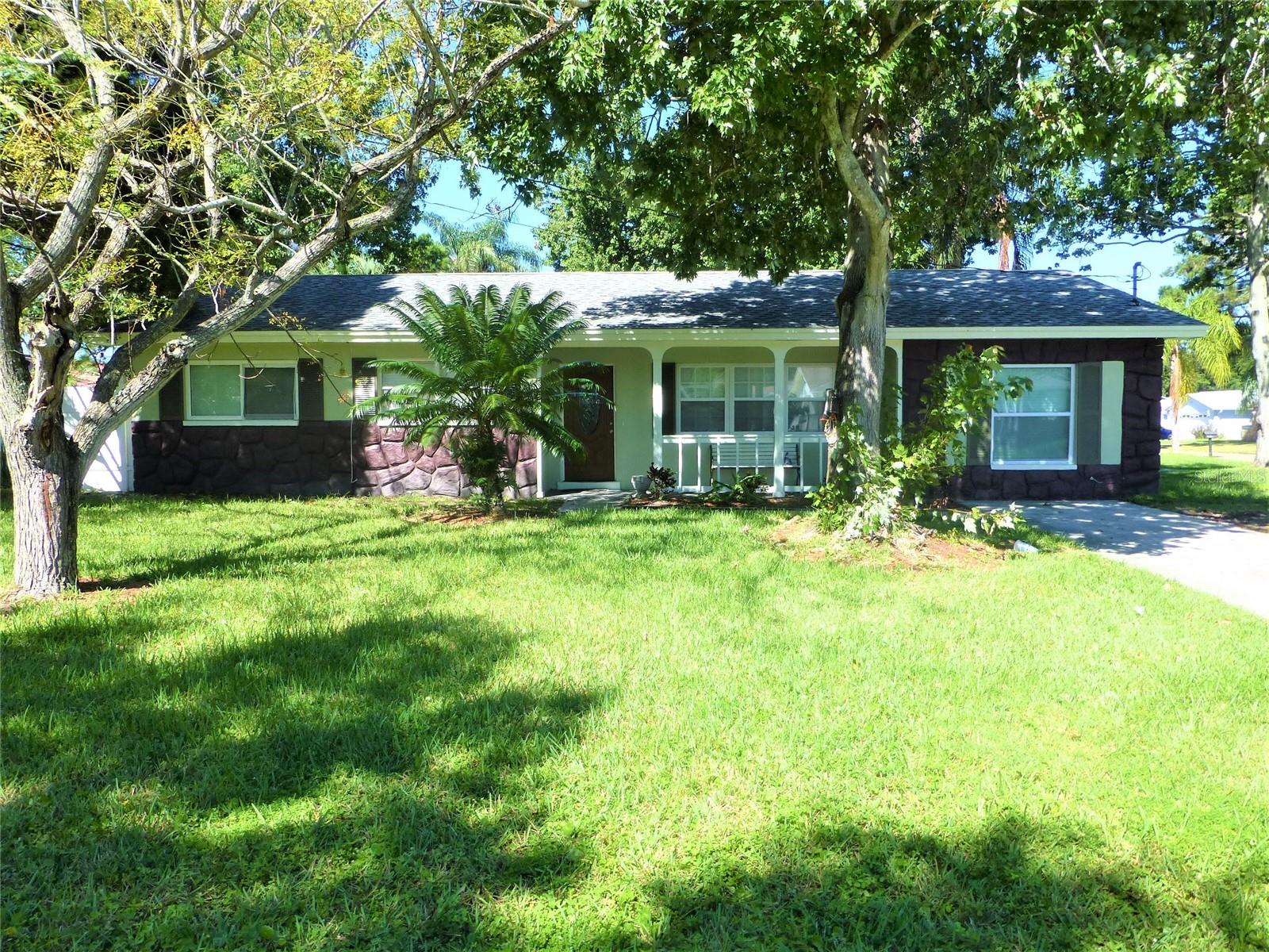 Discover timeless appeal in this beautifully maintained 4-bedroom, 2-bath vintage gem located in the heart of Safety Harbor. Nestled behind a fully fenced yard, this home blends classic character with thoughtful updates for comfortable modern living. Step through a charming etched glass front door into an inviting open floor plan featuring luxury vinyl flooring. The kitchen is both efficient and stylish, featuring stainless steel appliances, granite countertops, and warm oak cabinetry. An adjacent dining area with sliding doors brings in natural light and easy access to outdoor living. The split-bedroom layout provides privacy, with the carpeted primary suite tucked away off the living area. The primary bathroom includes a stand-alone shower and generous closet space. Three additional bedrooms are spacious and share a full hall bath. A laundry closet conveniently located off the kitchen adds functionality. Step outside to a covered cobblestone patio perfect for relaxing in the shade or entertaining overlooking the private, fenced backyard. Enjoy the charm of Safety Harbor with an easy commute to local beaches, Tampa, Clearwater, airports, and all the shopping and dining nearby. Spend your weekends strolling Main Street or fishing off the Safety Harbor Pier this home offers the best of Florida living! In addition to the advertised base rent, all residents are enrolled in the Resident Benefits Package (RBP) for $50.00/month which includes HVAC air filter delivery, credit building to help boost your credit score with timely rent payments, utility concierge service making utility connection a breeze during your move-in, and much more! More details upon application. Pets welcome, no aggressive breeds, no cats. Vacant and Available Now!