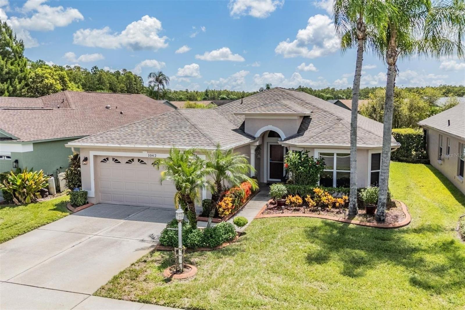 Pond views, designer touches, and an inviting layout make this home a true standout! WATER HEATER REPLACED 2016; A/C Replaced 2019; NEW ROOF 2022; HOA INCLUDES: INTERNET/CABLE, PAINT EVERY 5 YRS; LAWN/TRIM SHRUB MAINTENANCE; GARBAGE SERVICE. From the moment you enter, you’re greeted with a vaulted, open living and dining area filled with natural light, a neutral color palette, arched doorways. The sliding glass doors frame serene pond views and lead to a show-stopping enclosed lanai with AC in the Florida room—the perfect retreat to start or end your day. Complete with privacy shades and direct exterior access, it’s a space ready for relaxing or entertaining. Inside, easy-care laminate flooring flows throughout, complementing the home’s airy design. The thoughtfully designed kitchen features an island with stone countertop, stainless steel appliances, and abundant cabinet and workspace. A sunny breakfast nook provides the ideal spot for casual dining. The vaulted primary suite is a true retreat with pond views, private lanai access, and a spa-like bath boasting a granite double vanity and step-in shower with safety bar. Two additional bedrooms offer versatility—perfect for guests, hobbies, or a home office. A walk-in laundry room with storage cabinets and utility sink adds extra convenience. Every detail in this home has been designed for both comfort and function, making it move-in ready and waiting for your personal touch. 55 & FUN - LIVE THE HERITAGE SPRINGS LIFESTYLE - Resort style living at its absolute finest! Clubhouse with restaurant and bar, fitness, tennis, golf, cards, billiards, dancing and more! SUPERB TRINITY LOCATION, CLOSE TO BEACHES, DINING, SHOPPING, MEDICAL AND AIRPORT! Caution - Adults at Play!