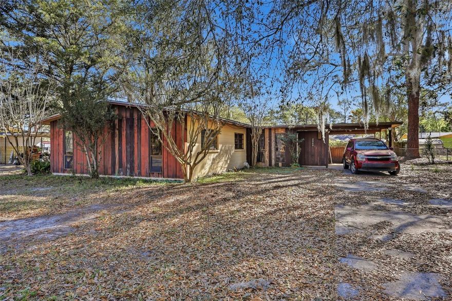 Tucked away on a sidewalk-lined street in the established Carol Estates neighborhood, this 4-bed, 2-bath concrete block home offers 1,639 sq ft of living space filled with authentic mid-century character. The interior features a spacious den with wood-paneled walls and a family room highlighted by a unique tongue-and-groove ceiling, while the kitchen serves as a central hub leading to the four comfortable bedrooms and bathrooms that feature charming vintage tilework. A functional mudroom houses the water heater and indoor laundry area complete with a washer and dryer, and provides direct access to the convenient carport. Situated on a level 0.23-acre lot with a partially fenced backyard, the property is just a short drive from the University of Florida, Gainesville Regional Airport, and local schools, with easy access to Ironwood Golf Course and the Waldo Road Greenway for outdoor recreation. Contact us today to schedule your private tour and see the potential of this charming NE Gainesville residence for yourself!
