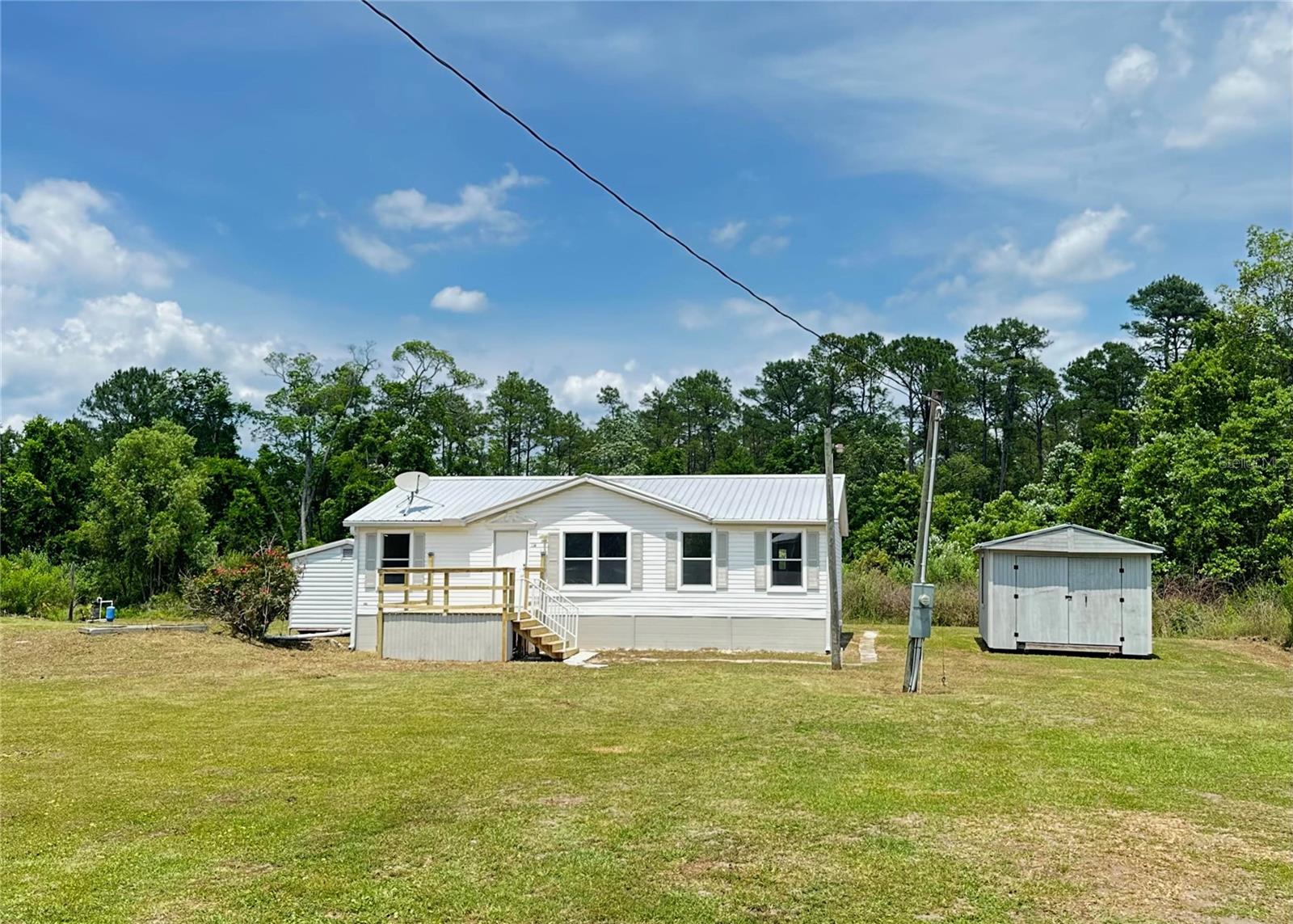 This 1999 mobile home has been freshly modernized and upgraded. It is conveniently located 20 minutes from downtown Palatka, offering you a balance of privacy, tranquility and easy access to shopping. A quick 15 minute drive is all it takes to reach numerous restaurants, shopping plazas, Walmart Supercenter, Home Depot and Lowes, and many more.
The home's nearly 3 acres of agricultural zoned land gives you a peaceful setting and ample space for homesteading activities. Lake Ocklawaha nearby is a great destination for fishing, boating and other water activities. The property is located in the cul-de-sac of a private road with only two friendly neighbors.
Newly upgraded kitchen, high quality commercial grade laminate flooring, new drywall and fresh paint, large format Bianco Fiore tiles in master shower, brand new interior doors and efficient LED lighting fixtures are just a few reasons to explore this opportunity.
The property boasts two electrified sheds:
1. 10x10 metal shed housing a whole house Rainsoft water purification system
2. 12x20 double door shed with ample space for storage or workshop.
Quick facts:
2021 new metal roof
2022 water heater
2016 A/C system (cool and heat)
Well and septic
New front porch with rails
Big, covered back deck