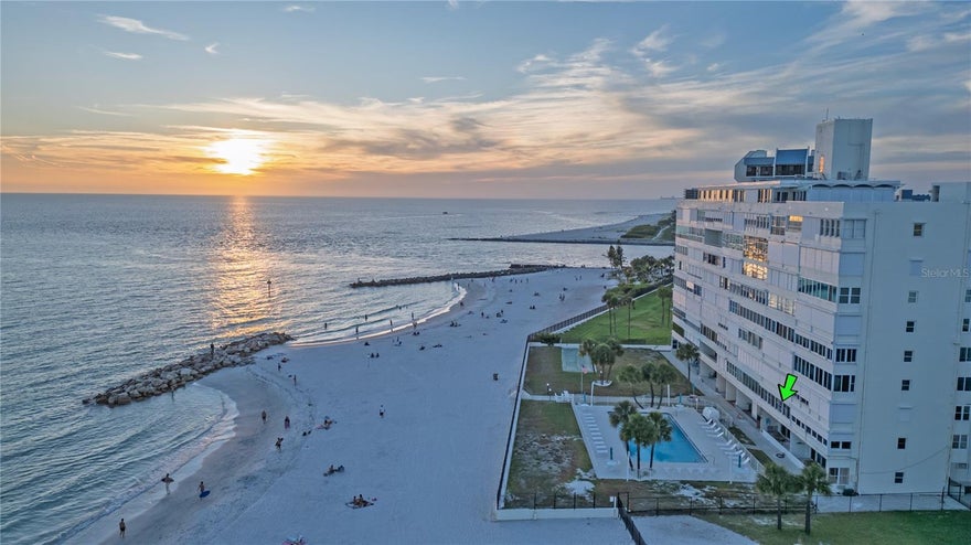 Welcome to Unit 202 at Starlight Tower, a rare opportunity to own a deluxe one bedroom beachfront residence that is larger than the standard one bedroom units at 7000 Beach Plaza in the heart of St. Pete Beach. Perfectly positioned on the second floor overlooking the pool and the Gulf of Mexico, this spacious unit offers the kind of coastal setting buyers dream about. Wake up to beach views, watch the sunset from nearly anywhere inside the unit, and enjoy direct sightlines to the sparkling pool, sandy beach and shoreline just beyond. Unlike the smaller standard one bedroom layouts in the building, this deluxe floor plan offers a more generous living and dining area, a comfortable bedroom, added hallway separation, excellent walk-in closet space and work-from home desk, and a useful utility and storage area. The oversized enclosed beachfront balcony expands the living space (public record show 840 sf not including the enclosed 28x7 balcony) and creates a bright, relaxing retreat with panoramic ocean views, Gulf breezes, pool activity, palm trees, and beachfront scenery year round. This building has an elevator to get to the unit, as you enter the kitchen provides a practical layout with full size appliances, generous cabinet storage, and a pass-through style connection to the dining and living areas. It offers a comfortable setup for everyday use while leaving plenty of opportunity for a future owner to update the space and make it their own. From the kitchen, dining area, living room, and enclosed balcony, the Gulf views remain the focal point, giving the entire residence a true beachfront feel. Starlight Tower places you just steps from the sand, making it easy to enjoy morning walks, beach days, and unforgettable Gulf sunsets without ever having to leave the property. St. Pete Beach was named the number one beach in the United States by Tripadvisor in 2021, adding even more appeal to this already sought after location. From inside the unit, the beachfront balcony, the pool deck, and the community grounds, you can enjoy the beauty of the Gulf and the convenience of direct beachside living. In a community where garage parking is rarely available, this residence stands out with a garage included in the sale. Paired with its larger deluxe layout, second floor pool and Gulf views, oversized enclosed balcony, and unbeatable steps to the beach location, this residence offers a truly special opportunity to own a beachfront retreat in the heart of St. Pete Beach.