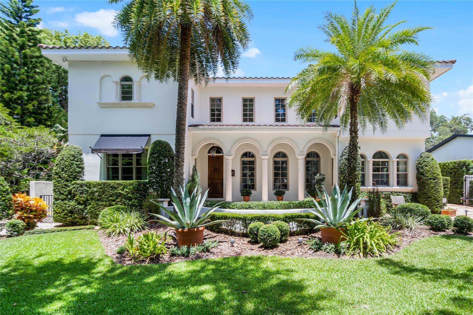 Exquisite Mediterranean Masterpiece in the Heart of Orlando!
Welcome to 419 Raehn St—a custom-built luxury estate where timeless Mediterranean elegance meets modern sophistication. This 4-bedroom, 3.5-bathroom residence offers an expansive layout, impeccable craftsmanship, and high-end finishes throughout.
Step inside to be greeted by soaring 20-foot ceilings, a dramatic curved staircase, and a stunning wood-burning fireplace in the grand formal living room. A retractable chandelier adds convenience and charm, while the seamless flow into the informal living area, complete with a custom entertainment center, a wet bar, and a temperature-controlled 600-bottle wine cellar, creates the perfect ambiance for both intimate and grand gatherings. French doors lead out to the backyard oasis.
The recently remodeled chef’s kitchen is a true showstopper, featuring professional-grade stainless steel appliances, a gas cooktop with pot filler, double convection ovens, an apron-front farmhouse sink, custom vented hood, and soft-close cabinetry. A butler’s pantry with a wine refrigerator connects to the elegant formal dining room, which boasts a built-in china closet, designer lighting, and rich wood floors.
Designed for versatility, this home offers a private office with exquisite wood coffered ceilings, built-ins, a walk-in closet, and its own entrance—perfect for working from home. Upstairs, a sprawling 20’ x 18’ loft opens to a 38’ x 10’ balcony with breathtaking downtown Orlando skyline views. The primary suite is a private retreat, showcasing wood floors, a dressing room, dual custom walk-in closets, a spa-like bath with a soaking tub, oversized walk-in shower, and dual vanities. Two additional bedrooms, a second loft, and a spacious laundry room with built-in cabinetry complete the second level.
Step outside to your private backyard paradise, enclosed by a stucco wall and custom iron gate. A covered 38-ft travertine patio extends around the heated saltwater pool and spa, creating a resort-style feel. Entertain effortlessly with the built-in grill and outdoor refrigerator, while the detached two-car garage and brick-paver driveway add both convenience and curb appeal.
With impeccable landscaping, designer finishes, and an unbeatable location, this home offers an unparalleled blend of luxury, comfort, and timeless beauty. Schedule your private tour today and experience the finest in Orlando living!