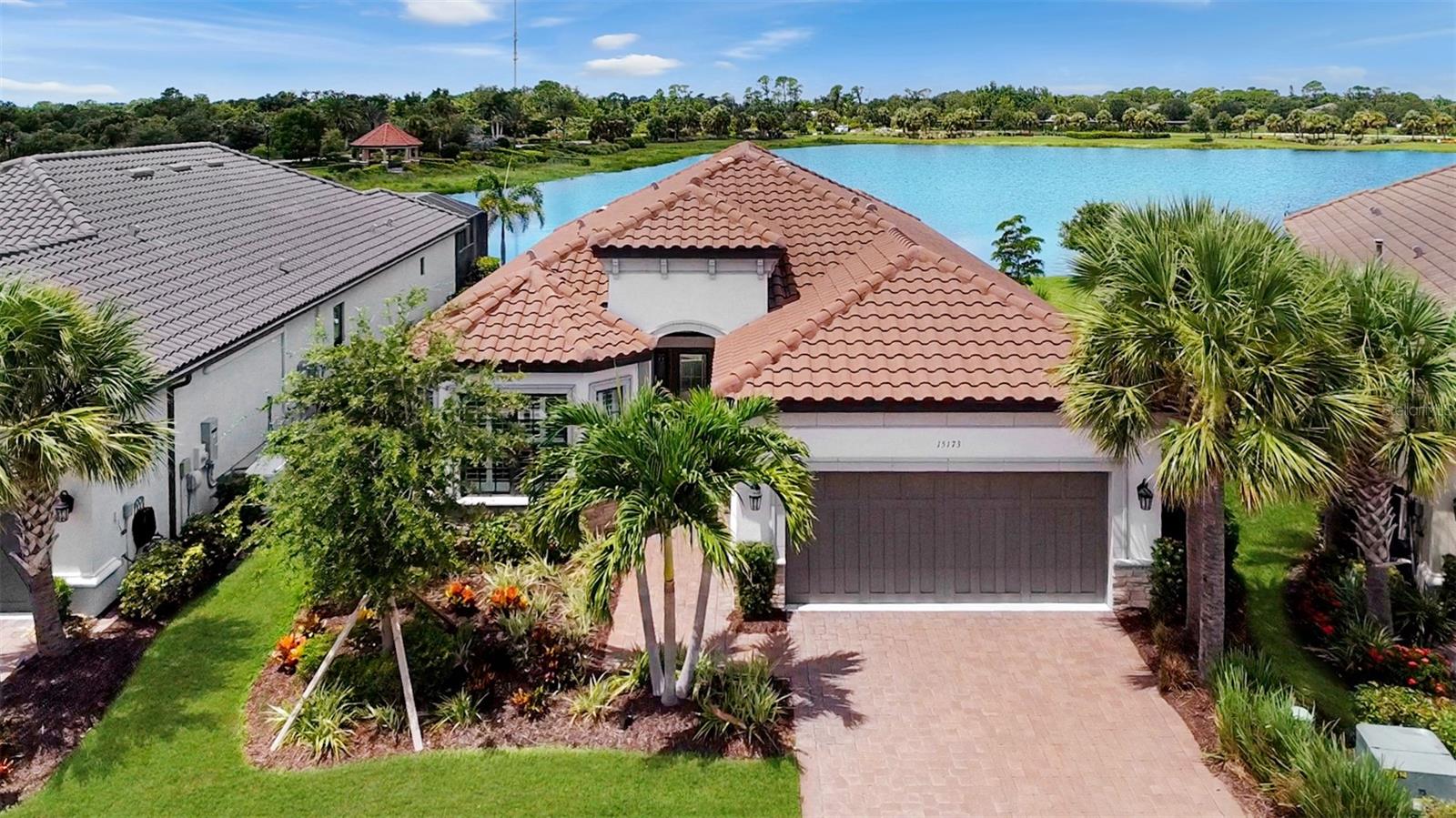 One or more photo(s) has been virtually staged. Welcome to Bellacina by Casey Key, one of the closest gated communities to the Gulf—ideally located just 2.5 miles from Nokomis Beach, with easy access to local restaurants, shopping, and all that coastal living entails. This beautifully designed and upgraded Taylor Morrison Piceno model offers 1,929 sq. ft. of open, single-level living with 2 bedrooms, 2 bathrooms, and a versatile study/den—perfect for a home office or flex space. From the moment you arrive, this home is ideally situated on a private .20-acre lot with a tranquil lake out back and a peaceful pond across the street—no front-facing neighbors! The entrance has a stunning front door with decorative glass inserts, flanked by matching sidelights and topped with a transom window, setting the tone for the elegance that continues throughout. Built for durability and peace of mind, the home features hurricane impact windows and doors, smart home technology, and a Nest thermostat. The open-concept layout is designed for modern living and effortless entertaining, featuring a chef’s kitchen with a natural gas cooktop, an expansive 11’ x 5’ quartz island accented by two brass palm leaf pendant lights, GE Café appliances with gold accents, a double oven, and a glass subway tile backsplash. The kitchen flows into the dining and living areas, highlighted by two triple sliding glass doors and a transom window that fill the space with natural light and provide seamless access to the west-facing screened lanai—perfect for enjoying spectacular sunsets over a large, tranquil lake. The outdoor area is made for year-round relaxation, complete with concrete pavers with travertine accents, a gas-heated, saltwater pool featuring a water fall feature and hot tub functionality, an extended roof for added shade, and pre-plumbing for a future outdoor kitchen. The primary suite is a private retreat with windows and double doors overlooking the lake and lanai, while a pocket door creates a private en-suite for the guest bedroom and bath. Additional interior features include laminate flooring, plantation shutters, ceiling fans, tray ceilings, frosted glass interior doors, and 24” x 24” porcelain tile flooring and walls in the bathrooms and laundry room. The laundry room is fully equipped with a utility sink and both upper and lower cabinetry for added storage. The spacious 2+ tandem garage can accommodate 3 cars or a boat, golf cart and extra storage. Residents of this resort-style, maintenance-free community enjoy premium amenities including a heated pool with cabanas, outdoor spa, 24-hour fitness center with showers, clubhouse with a chef’s kitchen and pool table, bocce ball courts, corn hole, grilling area, cozy gas fire pits, 4 lighted pickleball courts, a Har Tru tennis court, playground, and 2 dog parks. The community also features a private entrance to the Sarasota Legacy Trail and hosts a full calendar of events coordinated by an on-site Activities Director. Bellacina’s prime location puts you just 2.5 miles from Nokomis Beach, 5 miles from historic downtown Venice, 20 minutes to Siesta Key, and 30 minutes to downtown Sarasota and SRQ International Airport. This home is not just a gorgeous residence—it's a lifestyle!