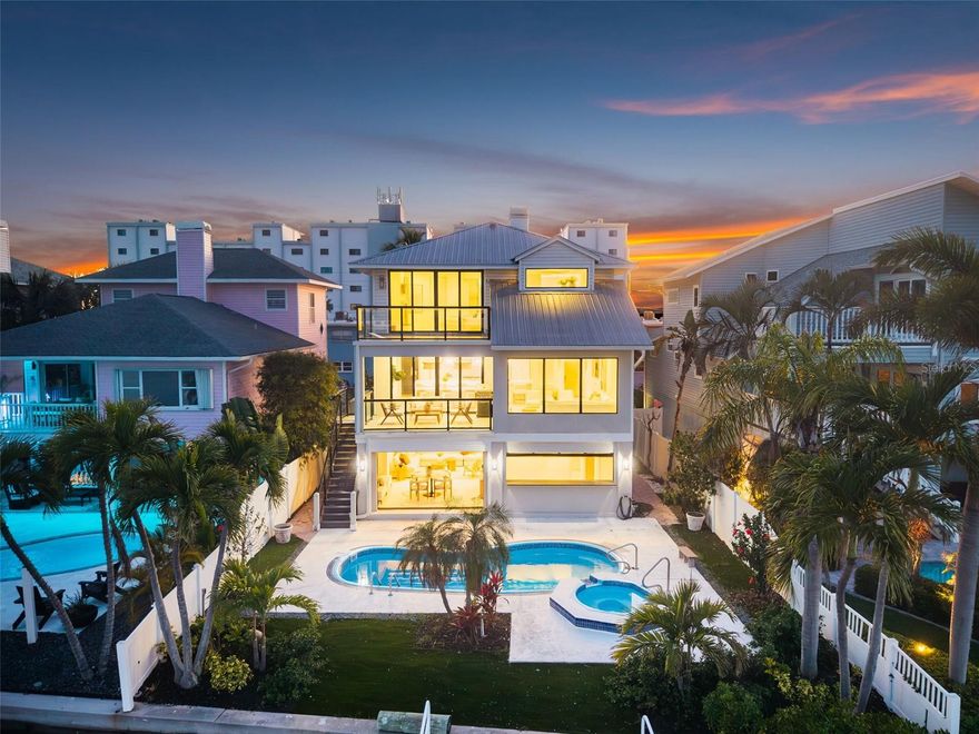 A statement of coastal elegance and architectural refinement, 8505 Blind Pass Dr. stands as a breathtaking waterfront masterpiece—crafted for the discerning buyer seeking unparalleled luxury, flawless design, and an effortlessly elevated lifestyle. Completely reimagined with no expense spared, this 3-bedroom, 3-bath, 2,600 sq. ft. residence blends bespoke finishes with sophisticated coastal living just moments from the Gulf’s white-sand shores. Upon entry, you’re greeted by an atmosphere of curated luxury: wide-plank wood-look tile floors sweep through the home, enriched by custom shiplap detail, designer lighting installations, and a cohesive palette reminiscent of an ultra-high-end seaside resort. Every space has been intentionally designed for beauty, comfort, and livability. At the heart of the home lies the showstopping gourmet kitchen, where panoramic water views frame an extraordinary culinary environment. A professional-grade 48" gas range, handcrafted Zellige tile, sculpted quartz surfaces, and a dramatic waterfall island elevate both everyday living and grand-scale entertaining. The expansive scullery—thoughtfully conceived as a true back kitchen—provides exceptional storage, prep space, and luxury utility. A glass-front, temperature-controlled wine room displays your collection as an art form. The entire top floor is dedicated to indulgence. The primary suite offers a sanctuary of serenity with hypnotic water views, a private balcony ideal for sunbathing or sunset gazing, and a sleek contemporary fireplace. The spa-inspired ensuite is a masterpiece of design, featuring floating vanities, exquisite artisanal tilework, a sculptural soaking tub, and a fully customized boutique-style dressing room complete with washer/dryer connection—bringing penthouse-level luxury to the waterfront. An adjoining flex room provides versatility for a private office, recreation lounge, or exclusive primary-suite sitting room, all while overlooking the shimmering Blind Pass waterway. The lower level elevates coastal living with exceptional functionality: a two-car garage, storage for boating, beach, and pool essentials, and a sophisticated pool-house room with dual full-height glass garage doors that open directly to the pool terrace. This creates a seamless indoor-outdoor enclave ideal for lavish entertaining and waterfront relaxation. For boating enthusiasts, the private dock and deep-water access provide the ultimate luxury—immediate entry to the Gulf and intracoastal waterways from your own backyard. Enjoy sunrise reflections over the water, golden coastal sunsets from the front of the home, and effortless walkability to the beach. A residence of this caliber is exceedingly rare—offering turnkey perfection, world-class amenities, and the pinnacle of Florida waterfront luxury. This is more than a home. It is a coastal masterpiece destined to impress.