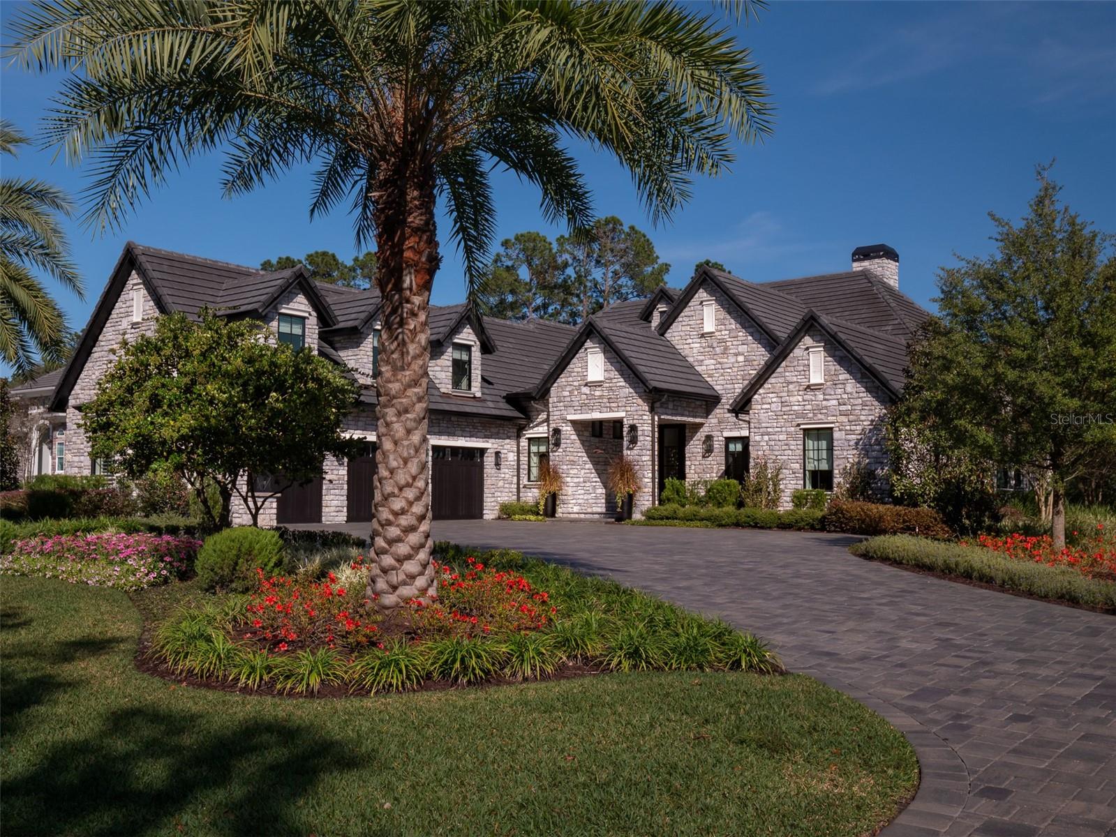 This gorgeous 2022 home is making its debut! Located in the esteemed gated community of Golden Ocala (next door to the World Equestrian Center!), this home sits right on the 13th hole, a replica of the famous 17th hole at St Andrews! This custom-built home is professionally designed and crafted, with an eye toward contemporary design meets classic comfort. Careful thought and planning went into all furnishings and fixtures, which you will find to be of superb quality and tasteful design; all furnishings are being offered with the home (with just a few exclusions). The living spaces are spacious and thoughtfully planned, offering an ideal area for both entertaining and daily living. The main living area features high beamed ceilings, fireplace, and built-ins with lighted shelving; a wine display wall provides the perfect backdrop for the bar area. The chef's kitchen features lighted cabinets, thick stone counters, apron sink, pot filler at gas range, coffered ceiling, and drop lighting. The centerpiece of the luxurious primary bedroom suite is a gorgeous marble fireplace; the en suite bath provides double vanities/sinks, soaking tub, double shower, and spacious walk-in closet. An upstairs bedroom suite is a great addition for overnight guests or a growing family. The outdoor living area of this home is ideal for entertaining or relaxing year-round. It features a stunning stone fireplace, spacious seating and dining areas, full kitchen, and roll up screens. Sit and relax at the pool and watch the golfers try their hands at that 13th hole!