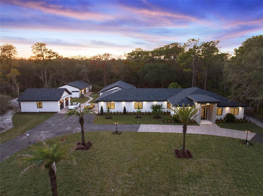 Be one of the few to own a NEWLY BUILT, acreage luxury estate in the coveted Markham Woods corridor. Encompassing 5 private, wooded acres, the main residence and guesthouse are peacefully situated 400 feet away from Markham Woods Road behind custom gates, secured with video confirmation access at entry. With a wooded lot size of 890x233, privacy is assured. The incredible renovation and expansion of this estate has been intimately curated by Heathrow Custom Homes, a boutique construction team renowned for its attention to detail. Absolutely everything is new and while the record shows 1982 construction, the property is undoubtedly 2023. A very livable 9,334 square feet under roof, this amazing estate spans three structures: the main residence with an attached 2.5-car garage, a guesthouse, and a detached two-car garage. The large circular driveway holds dozens of cars and easily allows for helicopter access. The main residence spans over 7,300 square feet under roof and nearly 5,100 square feet of living space, boasting an office at the grand foyer and extensive use of molding, hardwood flooring, and indirect lighting throughout. A chef’s delight is found at the jaw-dropping kitchen with WOLF cooking, hidden walk-in pantry, and an impressive 16-foot center island which is open to the vaulted ceiling great room. The guest wing boasts three private suites and a laundry room. The open, split-plan layout situates a centrally located pool bath and bonus room/possible 5th bedroom across the home where we also find the incredible primary suite. This private oasis enjoys a large walk-in closet with laundry space, a sitting room with views of the pool, and a luxurious bath. Stepping into the lanai introduces an alfresco atmosphere thanks to the summer kitchen and extended covered lanai trimmed with wood ceilings and sand-blasted marble pavers surrounding the enormous pool. The guesthouse is equally inviting and boasts two bedrooms, two baths, a laundry, a great room, kitchen, and flex room. Smart features give the owner elaborate control over lighting, the entry gate, and climate. There are pre-wires for seven zones of sound and seven security camera locations. Enjoy generous builder allowances of over $70,000 to customize this property to your preferences, please inquire for details. Ideally situated within moments of boutique shopping and dining in both historic Sanford and Lake Mary, this modern masterpiece is equally convenient to major hospitals, the attractions, and the beaches via the new 429/417 beltways, and I-4.