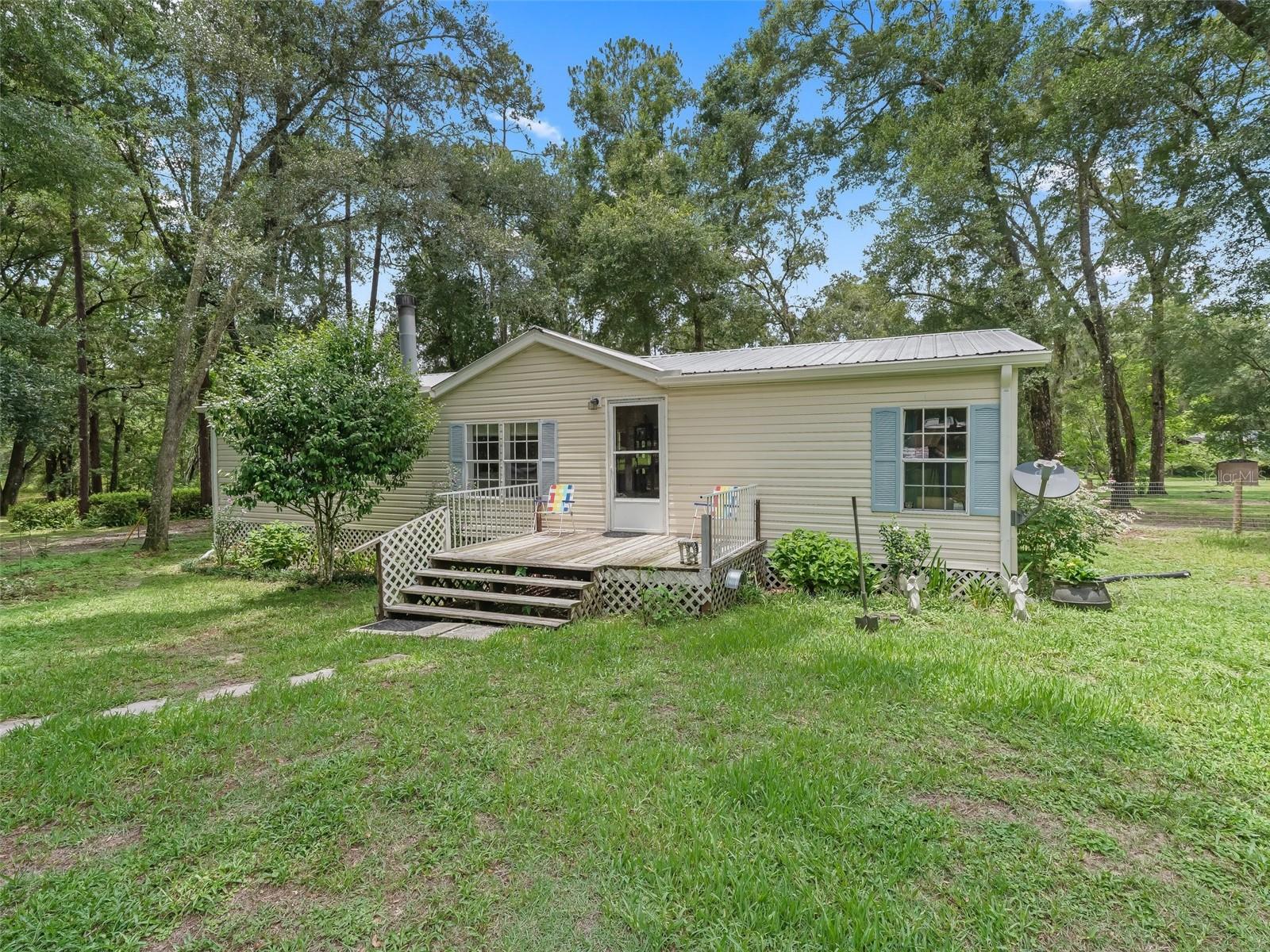 Escape to peaceful country living on your own acre of land just minutes from the Withlacoochee River. This well-kept mobile home offers peace of mind with a metal roof (installed in 2019), a new drain field this year, and a Leaf Filter gutter system with a transferable warranty. Inside, you’ll find a cozy kitchen with a built-in booth, perfect for morning coffee with a great view of your backyard pond. The split bedroom home is clean and ready for new owners to love it. The fireplace in the living room makes for a cozy setting, encouraging everyone to gather. Screened in back porch will be one of your favorite spots overlooking beautiful grounds. Out front is a shed, perfect for your gardening equipment and what nots. There are several public boat ramps close by, making those afternoon boat rides more possible without the "river front" price tag. Outside, enjoy colorful flowers blooming all around your yard — no flood zone, no HOA, just freedom to enjoy your space as you wish. Bring your boat, your toys, and your dreams — this slice of Florida is ready for you!