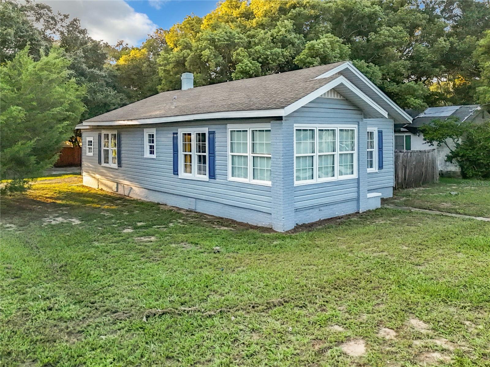 Located on a large corner lot just minutes from both downtown Eustis and Mount Dora with NO HOA. The kitchen has been fully renovated with upgraded granite counter tops, newer stainless steel appliances, custom cabinetry and tiled backsplash. The master bedroom offers dual closets and an attached half bath with vessel sink, along with a laundry area with plenty of room for a full size set and convenient laundering. Just down the hall, you'll find the guest bath with granite counter & top vessel sink, custom tiled rainfall shower and upgraded fixtures. The second bedroom shares hall access. The living areas are truly charming, with decorative brick fireplace and an oversized foyer that makes a cozy sunroom. Fully renovated, with tile, ceiling fans, and elegant lighting throughout. A multitude of windows let in SO MUCH natural light and the unique features of this home create a charming atmosphere.