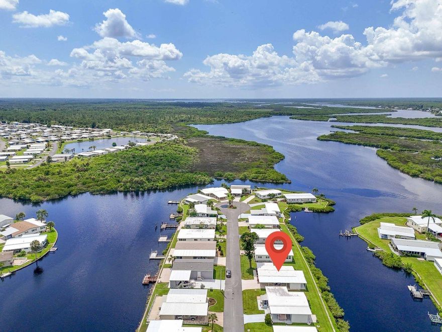 JUST REDUCED BY $10,000! Is this the 55+ coastal inspired, CANAL FRONT, COTTAGE-STYLE HOME you’ve been dreaming of? This TURN-KEY property is in a popular WATERFRONT community along the banks of the Myakka River which features a 90-slip boat marina, the only one of its size in the area, providing access to incredible boating and fishing opportunities. This furnished waterfront, 2 bedroom, 2 bath, 960 sq. ft. home has an additional 170 sq. ft. enclosed lanai and requires an HOA fee of only $150 per month! Primarily open concept, you’ll find a nice white kitchen with newer flooring, large deep sink and a dishwasher that make clean up easy after appetizers at the breakfast bar or in the bright dining area. A comfortable living room has sliding door access to both a breezy lanai with tranquil water views and a cozy screened front porch. The primary suite has those same peaceful canal views framed by updated windows (2019), a walk-in closet, and a private bathroom with walk-in shower. The guest bedroom closet hides the newer stackable washer/dryer and is just across from the hall bathroom. Outside, enjoy the quaint screened lanai in front with a friend for afternoon tea or the open patio in back for sunset gatherings. Nature lovers with be enchanted by the wildlife sightings here daily. A new roof was installed in 2019 and a 16' x 8' shed this year. This resident-owned community provides 2 swimming pools, hot tub, pickle ball, tennis, bocce, and shuffleboard courts, a fitness center and more. Attend social events, classes, dances, holiday parades (golf cart included with sale), trivia, bingo, etc., at the 17,000 sq. ft. clubhouse. Annual boat slip rental is available for only $100! You’ll be located a short drive to beaches, restaurants, shopping, live music venues, quality healthcare and I-75. This doublewide cottage is the perfect blend of comfort, tranquility and affordability. Time to schedule a showing!