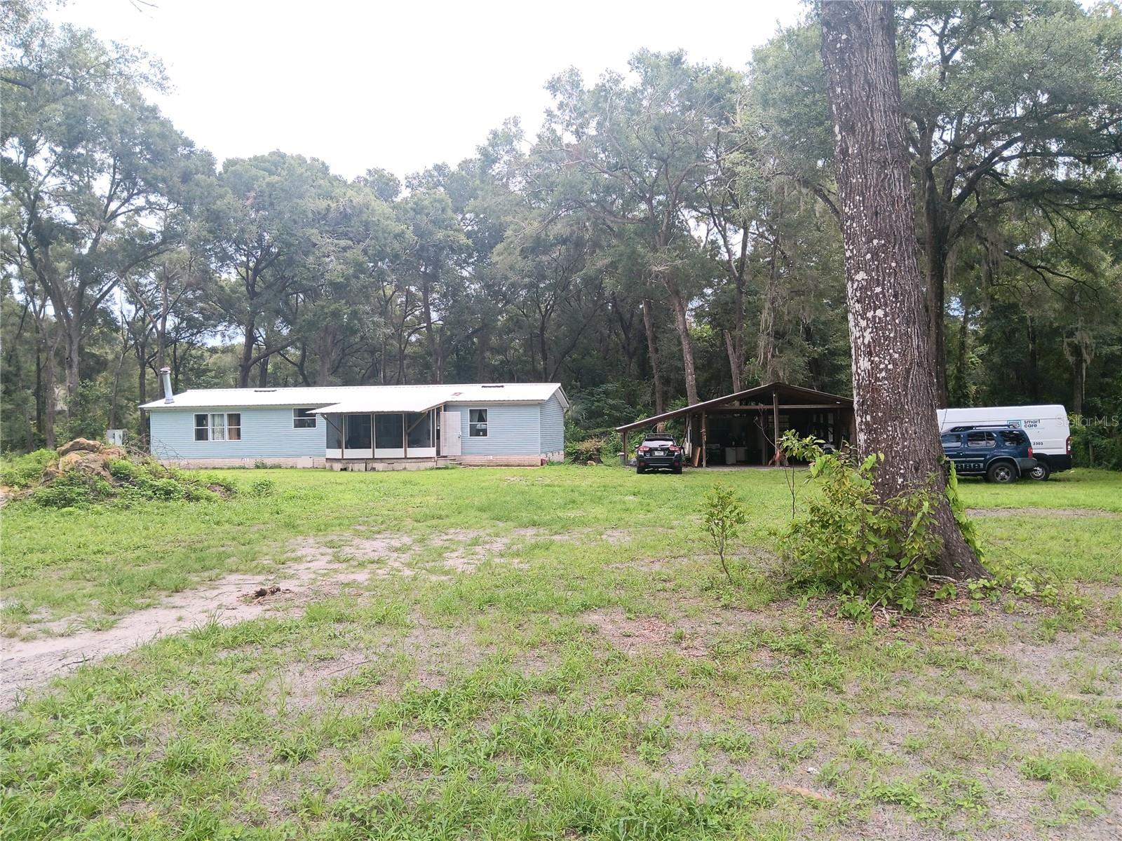 Looking for acreage property with a touch of rural charm in Summerfield?, this is the one. A 1,716 sq.ft. doublewide mobile home with 3 bedrooms 2 bathrooms, on a 1.97 acre lot, fully recently remodeled. New air conditioning, new metal roof, new flooring. Enclosed front porch welcomes you to a split concept layout inside, ample dining and living area for the family, good size open concept kitchen, additional family room with a fireplace. Awesome master bedroom with its own master suite and walking closet, good size secondary bedrooms each with its own walking closet. The property has a huge building structure with a pit for working cars and a back room for storage and tools. You can do wonders on this property.