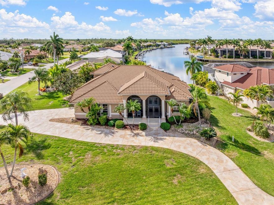 Set along a Gulf-access canal in the coveted Burnt Store Isles community, this beautifully maintained 4-bedroom, 3.5-bath waterfront home offers timeless Florida living with peace of mind, numerous updates, amazing sunsets, and square footage galore. This home offers just under 2,900SF  of living space, features a 1½-story layout, and 12ft ceilings in the main living areas. A large screened-in front porch with space for seating greets you. Beyond are double beveled-glass entry doors that open to an airy foyer and living space with immediate water views. Brazilian rosewood flooring enhances the living and dining rooms, while ceramic tile flows through the kitchen and additional living areas. The centrally located kitchen showcases granite countertops, hardwood cabinetry, Samsung appliances, a center island with slide-in stove, walk-in pantry, breakfast bar seating, and picturesque sunset and water views. A split-bedroom design provides privacy. On the main floor you will find a spacious owner’s suite with Roman shower, garden tub, dual granite vanities, plantation shutters, and lanai access, and 2 generously sized guest rooms on the other side of the house. Head upstairs for a private guest suite that enjoys sweeping water views, balcony access, and its own bath—ideal for visitors or multigenerational living. Outdoors, the corner lot impresses with a circular driveway, patterned coating, cement dock, irrigation system, and a stunning screened two-story pool deck featuring a pool with fountain and waterfall, outdoor shower, storage, and an expansive covered lanai with electric roll-down sun and privacy screens. Recent improvements from 2018–2025 include a METAL ROOF  (2023), IMPACT WINDOWS, WHOLE HOME GENERAC GENERATOR (2024), SOLAR WATER HEATER, UPGRADED INSULATION, SOLAR ATTIC FANS (2023), WHOLE-HOUSE WATER TREATMENT WITH R/O, GUEST SIDE A/C 202, POOL EQUIPMENT (2022), LIGHTING, FANS, AND MORE — WINDOWS PROTECTED WITH EITHER IMPACT GLASS OR STORM SHUTTERS, INCLUDING ELECTRIC SHUTTER FOR FRONT ENTRY. Additional highlights include an oversized garage with workbench, storage, second refrigerator, 50-amp RV outlet, and a remote-controlled privacy screen, as well as a TRANSFERABLE HOME WARRANTY. Burnt Store Isles in Punta Gorda, a deed-restricted community, is centrally located close to grocery shopping, yet biking & walking friendly. Twin Isles Country Club, provides optional golf membership and social opportunities, and is located in the neighborhood. Downtown Punta Gorda is also just a few miles away, offering quaint shops & restaurants.