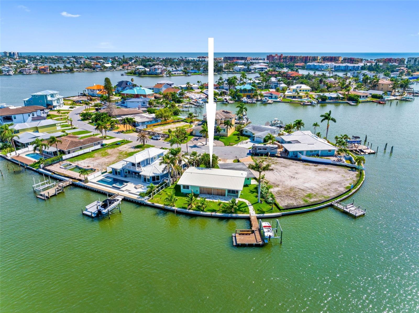 Nestled in the highly desirable coastal enclave of North Redington Beach, this exceptional property presents a rare opportunity to create a bespoke waterfront haven. This prime, oversized point lot boasts over 110 feet of reinforced seawall, providing an ideal foundation for constructing a custom dream home. The property's deep sailboat water access, coupled with an existing dock and lift, caters to the avid boater and water sports enthusiast. Enjoy unobstructed water views, offering both spectacular sunrises and captivating sunsets, painting the sky with vibrant colors. A leisurely stroll will lead you to the pristine Gulf of Mexico, allowing for effortless enjoyment of the beach lifestyle.This substantial lot provides ample space to accommodate a residence exceeding 3,500 square feet, offering the flexibility to design a one or two-story home elevated over parking. The generous dimensions also allow for the inclusion of an oversized garage, providing abundant space for vehicles and storage. Imagine crafting a residence perfectly tailored to your discerning tastes, capitalizing on the panoramic water vistas and the tranquil ambiance of this coveted location. This North Redington Beach property represents an unparalleled opportunity to embrace the waterfront lifestyle and create a legacy for generations to come.