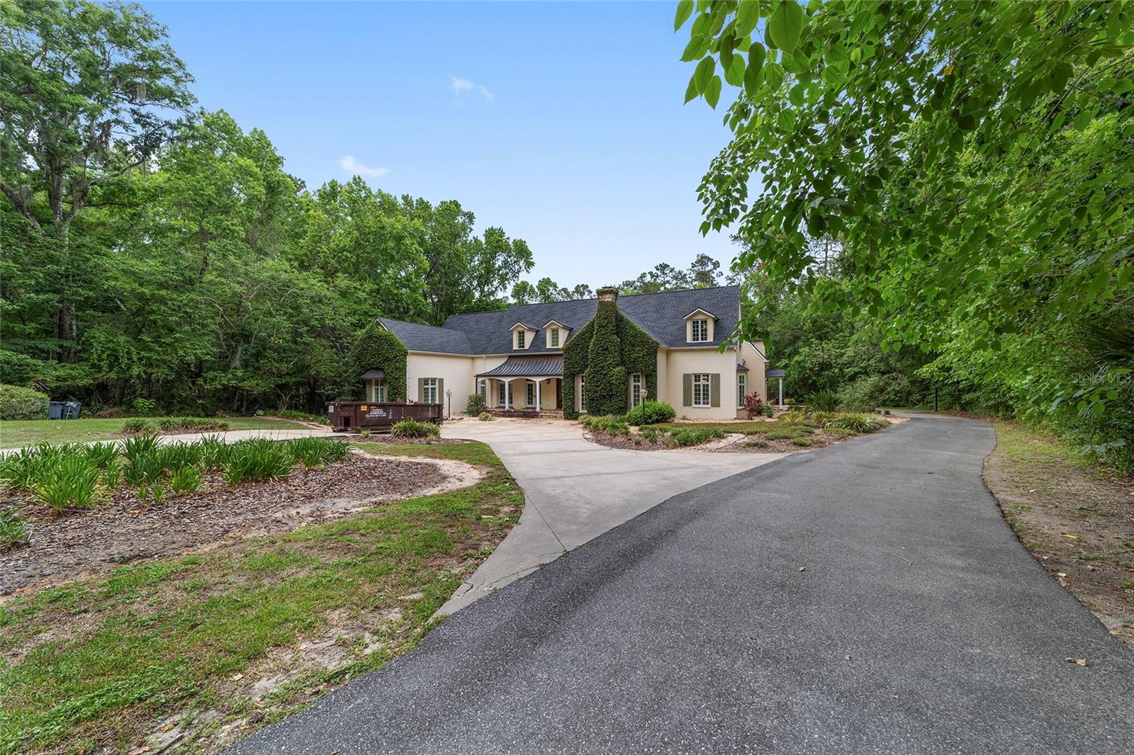 Welcome to your private estate in the distinguished community of Polo Lane! This beautifully appointed 4-bedroom, 5-bathroom residence is set on a sprawling 7-acre lot, offering the perfect blend of privacy, space, and luxury—just minutes from Ocala’s amenities. Enjoy the tranquility of wide-open living with the convenience of being close to town.
Step inside to an inviting open floor plan filled with natural light and neutral finishes throughout. The heart of the home is a charming kitchen featuring character-rich terracotta tile, ample counter space, and seamless flow into the living and dining areas—perfect for entertaining.
The spacious primary suite is truly a retreat, complete with an additional attached room that provides flexible space for a sitting area, home office, or nursery—all tucked away from the main areas of the home for added peace and privacy. Step out onto your private balcony to take in views of the serene backyard and pool. The en-suite bath is complemented by a large walk-in closet with custom built-ins.
Each additional bedroom is generously sized with access to its own bathroom, offering comfort and privacy for family or guests. A large, well-equipped laundry room includes a sink, counters, and storage—ideal for any busy household.
Outdoors, your personal oasis awaits: a sparkling in-ground pool, mature trees, and an outdoor kitchen under a vine-wrapped pergola that exudes timeless charm and brings nature right to your backdoor. With 7 acres to enjoy, the lot offers ample distance from neighbors while still being part of an HOA community.
Additional highlights include a 2-car garage, new windows and doors (2023), roof (2021), HVAC (2016), and water heater (2022). This is a rare opportunity to enjoy luxury living in a one-of-a-kind setting—schedule your private showing today!