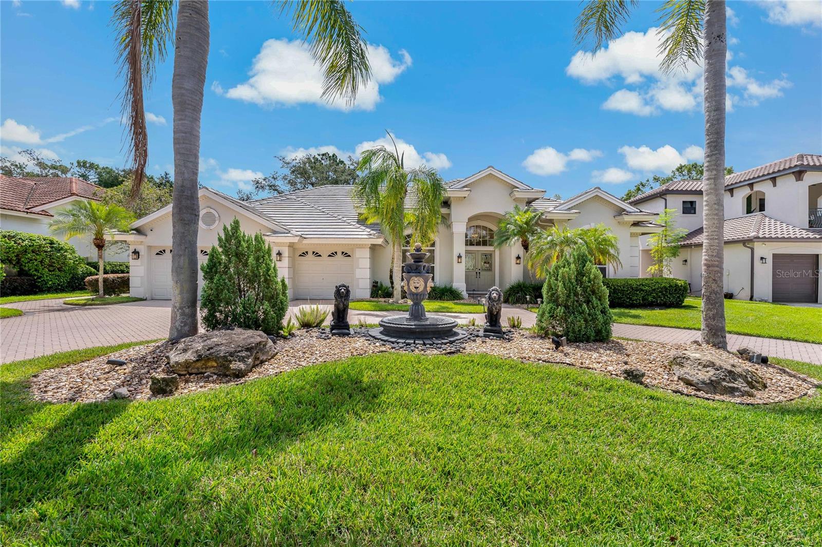 Welcome to this stunning luxury residence located in the gated community of Saddlebrook. Sprawled across nearly half an acre of manicured land, this 4-bed, 3-bath home with a bonus den/office offers over 2,700 sqft of elegantly designed living space. As you approach, the home's circular paver driveway and central fountain make a grand impression. The oversized 3-car garage features epoxied floors and a side-loading door for a golf cart. Inside, you'll find crown molding, architectural details, and a split-bedroom layout. The home offers both formal living and dining rooms, along with a spacious family room equipped with triple-pocket sliding doors that open up to breathtaking views of the heated pool. The chef's kitchen is centrally located, featuring granite countertops, a large island, stainless steel appliances, and ample cabinet space. The luxurious primary suite includes sliding glass doors that lead to the pool area, along with two walk-in closets. The ensuite bathroom feels like a spa with elegant tiling, a large soaking tub, dual vanities, walk-in shower, and a private water closet. In addition, there are three spacious bedrooms and two well-appointed full bathrooms. A dedicated laundry room includes extra storage and a utility sink. Step into the screened-in outdoor living area and enjoy your own resort-style pool and jacuzzi surrounded by a paver deck and lush landscaping. An outdoor kitchen with a built-in grill, sink, and island make entertaining effortless. Unwind by the gas fireplace or gather around the fire pit seating area, perfectly nestled behind sculpted privacy hedges. As a resident of Saddlebrook, enjoy 24-hour guard-gated security and access to two 18-hole Arnold Palmer-designed golf courses, multiple tennis & pickleball courts, scenic trails and much more. Located in the heart of Wesley Chapel, you're minutes from I-75, Tampa Premium Outlets, The Shops at Wiregrass, and a short drive to downtown Tampa. Additional updates include: instant water heater (2022), new pool pump (2025), water softener, new fridge (2024), roof (2014). Schedule your showing today!