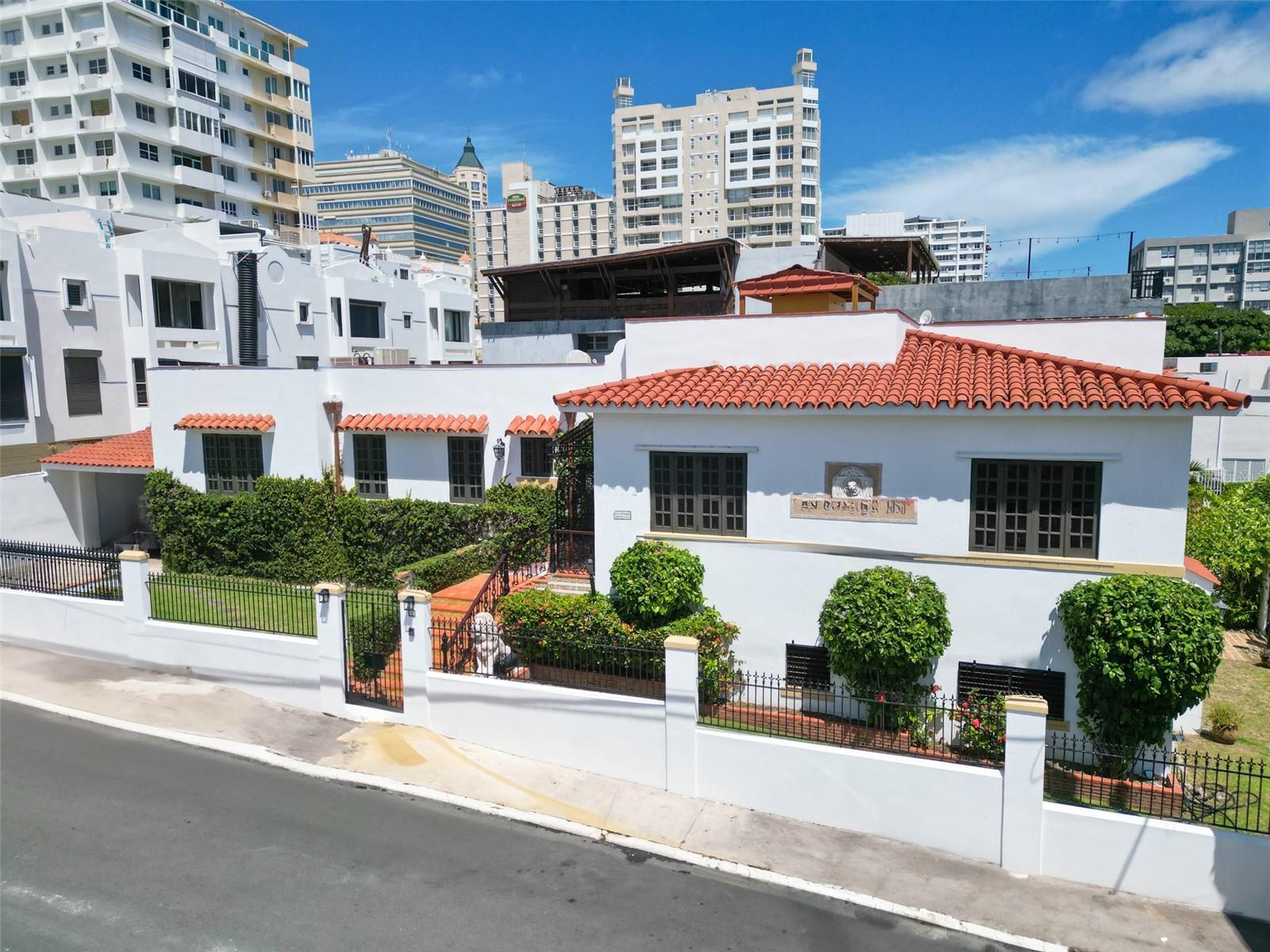 Located on one of the most charming and quiet residential streets in historic Miramar, this fully remodeled Spanish Colonial home offers timeless elegance with modern comfort. Sitting on a corner lot, the two-level residence spans approximately 4,500 square feet and features six bedrooms and four and a half bathrooms. Thoughtful renovations include a redesigned kitchen with high-end appliances and custom wood cabinetry, updated bathrooms, new floors, windows, and roof. Original architectural elements such as arched wrought-iron doors and terracotta tile details have been carefully preserved to honor the home’s heritage.
Ideal for entertaining, the property boasts a large covered terrace with a built-in bar and lounge area, plus a beautifully tiled plunge pool with tropical landscaping. Additional features include a full-power generator, water cistern, inverter A/C units (5-ton), and a four-car covered garage. Just steps away from Condado and top restaurants, this is a rare opportunity to own a classic yet turnkey home in one of San Juan’s most coveted neighborhoods.