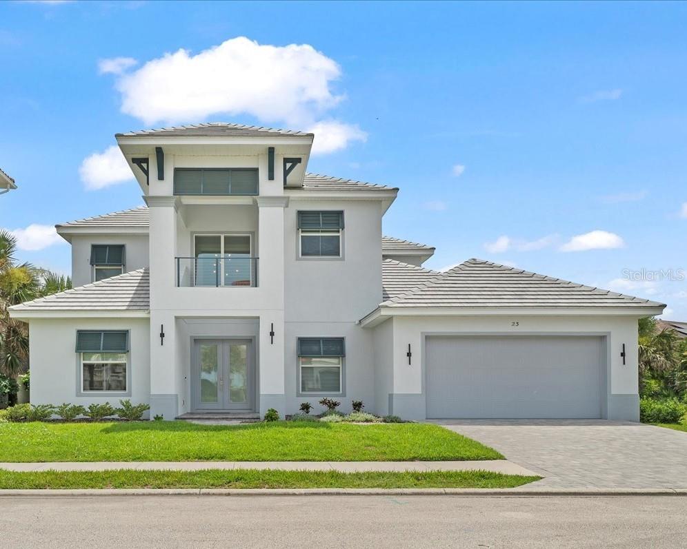 Welcome to 23 Ocean Ridge Boulevard North – a coastal contemporary beachside stunner giving you that new home feel without the wait to build! Nestled on a private lot in the Ocean Ridge neighborhood inside Ocean Hammock, this custom-built and designed home is the perfect combination of luxury while promoting easy coastal living and all the conveniences you desire.
Stately curb appeal greets you as you enter the home via large double doors. The dramatic two-story entry foyer flows into the light and airy open concept first floor. A lower-level bedroom currently used as an office space provides direct access to a full bathroom, giving flexibility as work or bedroom space. A formal dining room flanks the entry foyer with plenty of seating for 10+ in an intimate setting, overlooking the lush street landscaping through large windows. The main living area provides ample seating space for your large group. This space can easily divided into dual seating areas to enhance entertaining, and complete with a large collapsible slider to the screened lanai. A highlight of this space is the floor to ceiling stone linear fireplace, providing lovely ambience for relaxation. The adjacent kitchen features 42-inch cabinetry, quartz countertops, glass tile backsplash, walk-in pantry and separate breakfast nook, overlooking the sparkling pool and spa. A first-floor primary suite features a large bay window overlooking the pool, tray ceiling, soaking tub, large walk-through shower, double sink vanity with lighted LED mirrors and seated vanity space, and walk-in closet with custom closet system. Rounding out this well-designed lower level is a laundry room with extra storage.
Heading up the hardwood staircase, you are greeted by a large loft space. Currently used as a home gym, the options are limitless of this space! After your workout, open up the stackable sliding door and cool off on your back screened balcony with a view of the 6th fairway of the world-renowned Ocean Course of The Club at Hammock Beach. Want a relaxing but entertaining night in? Head to the tiered media room with surround sound and kick up your feet for a great movie or some karaoke – but don’t forget to grab some popcorn and snacks at the mini-bar on your way in! A special treat off the media room is floored attic storage! 3 spacious bedrooms and 2 full baths complete the upstairs living area of this home.
Outdoors, you are greeted by the lush Florida landscaping on this preserve lot. A custom-designed screened and heated pool and spa provides great fun and relaxation for the whole family, while being steps from the north walkover for direct beach access.
Have a few vehicles? Don’t let the 2-car garage door fool you! This home boasts a 3 car tandem garage that is already pre-wired for two additional vehicle lifts – perfect for the car aficionado! This garage is spotless with a upgraded lighting, finished floor and workshop space for your projects!
In addition to the amenities provided by this property, enjoy the safety and security of the gated Ocean Hammock community. Additionally, optional beach club and full golf memberships are available for purchase at The Club at Hammock Beach! Easy access to area restaurants, medical and shopping. With easy access to Orlando, Jacksonville and Daytona Beach airports, travel to and from the area is a breeze. Don’t miss this fantastic opportunity in one of the area’s most desired communities!