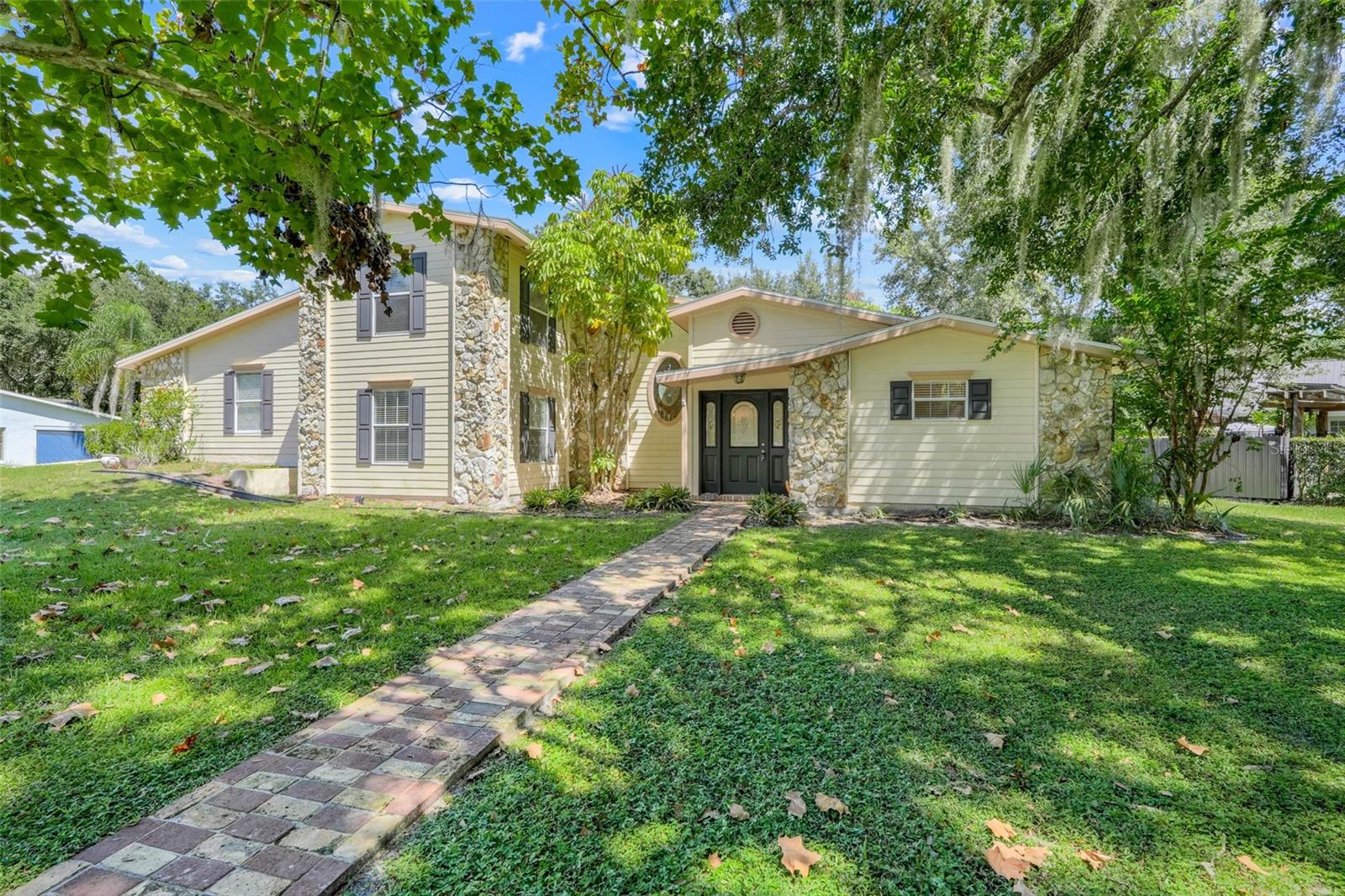 Set on a spacious 0.40-acre lot in the mature Regal Oak Shores community, this home offers room to spread out while still being just minutes from downtown Kissimmee. The stone front, shady trees, and paver walkway give it a welcoming feel, with a side-entry two-car garage tucked to the side. Inside, you’ll find a formal living room with built-ins, a comfortable family room, and a bright kitchen with wood cabinets, recessed lighting, and classic white appliances. The primary suite is located on the first floor and features dual sinks and a private water closet. Upstairs, two additional bedrooms share a full bath. Step out back to your oversized, tree-lined yard with patio and storage shed. Whether you dream of a garden, a play area, outdoor kitchen, or a peaceful retreat, there’s plenty of space here to bring your ideas to life. Conveniently located near US-192, the Turnpike, shopping, dining, medical centers, and Orlando attractions, this home is ready for you to make it your own.