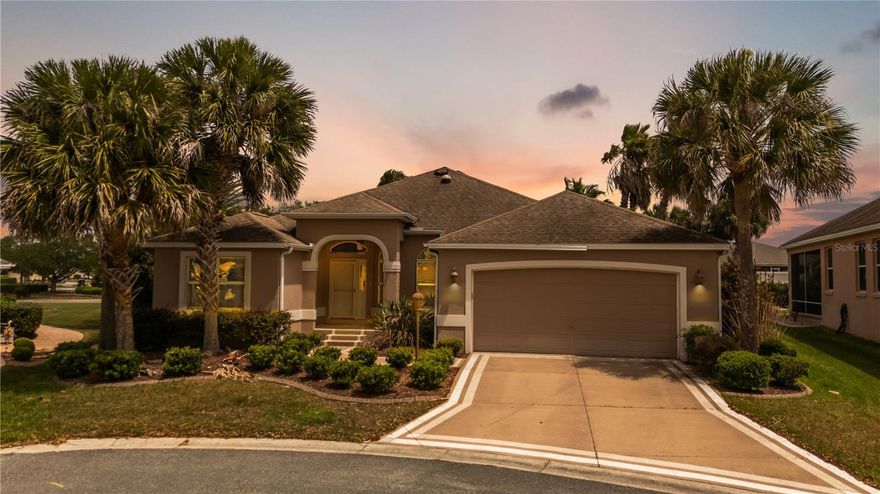 TURNKEY!! MINUTES—AND AN EASY WALK—to Lake Sumter Landing Market Square! Tucked away on a quiet cul-de-sac in the Village of Sabal Chase, this beautifully furnished 3-bedroom, 2-bath Gardenia model offers the perfect blend of location, privacy, and upgrades. With no rear neighbors the setting is both peaceful and highly desirable. As you arrive, you’ll immediately notice the exceptional curb appeal, highlighted by enhanced landscaping and an epoxy-painted driveway and walkway. A charming covered front porch welcomes you inside to a bright foyer featuring a transom window and side glass panel, setting the tone for the open and split floor plan. The interior offers a spacious layout with a seamless flow between living and dining areas, ideal for both everyday living and entertaining. The kitchen is well-appointed with rich cherry cabinetry, granite countertops, black appliances, a breakfast bar, and convenient pull-out shelving, all connecting to a cozy dining nook. One of the standout features of this home is the incredible outdoor living space. The covered lanai has been extended an additional 4 feet 4 inches and opens to a mansard-style birdcage enclosure, creating a true backyard retreat. The summer kitchen is a crowd favorite, complete with a grill, sink, vented hood, and refrigerator—perfect for hosting. There is also an above-ground hot tub for relaxing evenings, and if you’ve ever dreamed of adding a pool, there is room to make it happen. The master suite is a private escape with two large walk-in closets and sliding glass doors leading directly to the lanai. The ensuite bathroom features dual vanities and a seamless glass shower. An additional guest bedrooms is located on the opposite side of the home, offering comfort and privacy. Additional features include a gas-wired home, solar tubes for natural light, a water filtration system, and a screened front entry. Major peace of mind upgrades are coming— the seller is installing a BRAND NEW ROOF, HVAC, and HOT WATER HEATER prior to closing, making this home an exceptional value. Located centrally between Lake Sumter Landing and Brownwood, and within close proximity to the Sabal Chase pool and postal station, this home truly captures The Villages lifestyle. Whether you’re looking for a full-time residence or seasonal retreat, this one checks all the boxes.