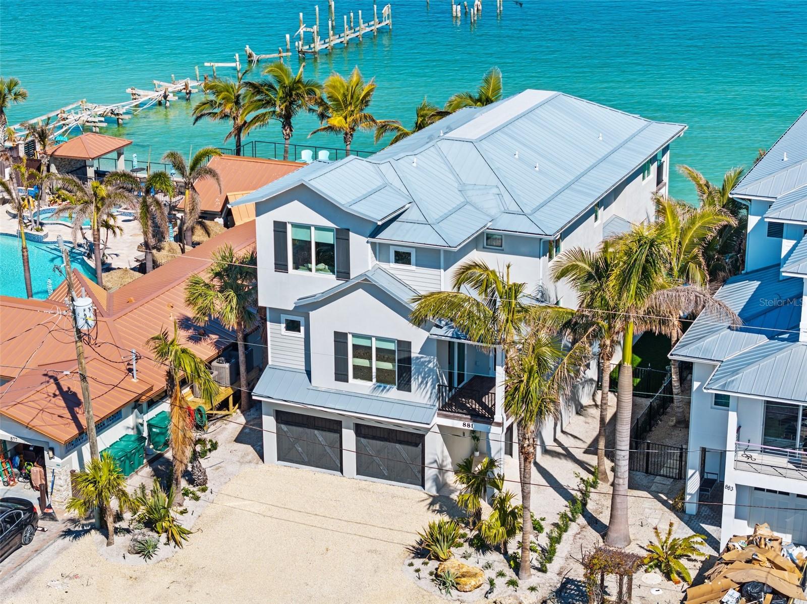 Absolutely incredible renovated 7 bedroom, 7.5 bathroom pool home DIRECTLY on the stunning Bay offering sunset views and plenty of fun in the sun! As you arrive you will appreciate the lush landscaping that surrounds this lot and the spacious two car garage on the bottom floor, inside there is an airy open layout with the entire main level designed for gatherings, complete with beach access, a luxurious pool & spa, and a fully covered deck with space for dining, grilling out, and multiple spots for just soaking it all in and pure relaxation! Up the stairs you will find the laundry closet and the main entertainment space, this open floorplan has an oversized living room, an inside and outside dining area and a chef’s dream kitchen, all overlooking the Bay from the lovely patio! The kitchen is fully equipped to prepare a nice meal in between swimming laps in the pool, with beautiful wood flooring, quartz countertops, a large center island, sub-zero appliances and TWO drink fridges, your beer and wine will stay chilled for all of your daily adventures! There are two bedrooms on the second floor with one of the bedrooms having its own personal patio, walk-in closet and en-suite bathroom! On the top floor you will find the other 5 bedrooms, each with its own private en-suite bathroom. The amazing master suite is just adjacent to the stairs and offers pristine water views from its wall-to-wall screen doors, there is a seating/office space at the corner, a massive walk-in closet and an exquisite en-suite bathroom with dual vanities, a custom tiled walk-in shower and a soaker tub perfect for washing away your worries! Currently used as a vacation rental, this home would continue to be a prime investment property for many years to come. Centrally located, right on Anna Maria Island with NO HOA, where you can take in the island on foot or by bike! Take endless walks on the beach as you watch dolphins swim by, enjoy all of the nearby restaurants such as the Rod & Reel Pier (which can conveniently be seen from your balcony!), open your doors and windows and let the ocean lull you to sleep each evening, this home offers something for EVERYONE! This is a SUCCESSFUL RENTAL PROPERTY and already has FORWARD BOOKINGS IN PLACE.