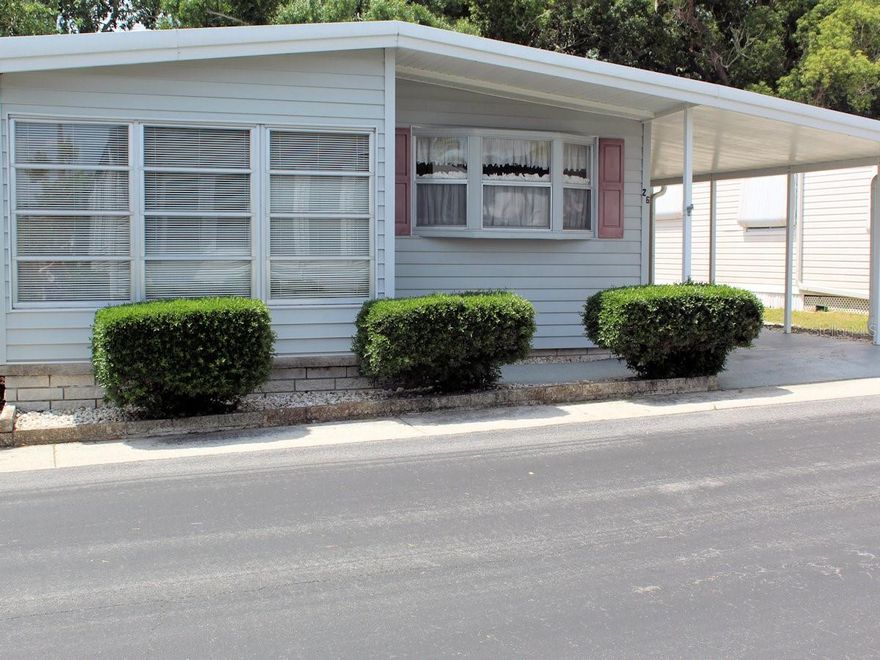Here is the perfect pet location within the protective confines of Palm Hill Mobile Home Park, a 55+ community where each day feels like a vacation. This charming two bed, two bath manufactured home boasts a generous screened porch overlooking an expansive backyard.  What a perfect spot for you and your furry friend to enjoy restful days.  From golf outings, tennis, pickleball, bocce ball, shuffleboard, pools, jacuzzies, to clubhouse dances, there are many opportunities to make new friends. The community has one reasonable monthly fee of $594 which includes water, trash removal, lawn care, cable and internet. The front kitchen is well laid out and has front bay windows, refaced cabinets, quartz counter tops, updated sink and faucet, range, overhead microwave, refrigerator and dishwasher.  One of the countertops has plenty of room for quick lunches or snacks. There are ample upper and lower cabinet space and an additional storage cabinet.  Behind the kitchen is the sit-down dining room.  Floors here and throughout most of the home are laminate with plywood sub floors.  Most of the furniture will stay for the new owners. Across from the dining area is the living room.  Windows on either side of the living area have been updated and are double pane. Decorative molding throughout the interior gives a finished touch.  French doors lead to the front bonus family room with tile floors. Front windows and an exit door make it easy to visit neighbors. The primary bedroom is situated in the back.  This is attractively laid out with two generous size closets, attractive Haverty furniture, and an additional closet leading into the ensuite bath area.  This special bedroom is open to its own private suite which could also be used as a den area.  French doors lead to the exceptional enclosed screen room with its superb private backyard beyond.  The smaller guest bedroom is nearer to the living area and has adequate closet space.  Both baths have tile floors.  The ensuite has a large counter vanity area and a door leading to the toilet and shower while the guest bath has a tub with shower. This well laid out pet area home is move -in ready.  Most furniture will stay except for a Grandfather clock and special wall hangings. Light siding, front windows framed by manicured bushes and side trimmings along the carport emphasize the exterior.  The carport posts are updated and there is an attractive decorative kitchen door.  The home, shed and carport have an AMS roof over.  At the end of the carport there is a door leading into the utility shed. This area is divided into two sections with the first part being a storage space and beyond an opening leading to the space with washer, dryer, and soaking sink.  Plenty of space here.  Note also there is a door from the screened room leading inside to the shed. A three-ton air conditioner was installed in 2024. To see this fine property please call for a quick appointment before it is gone.  A share is included in the price.