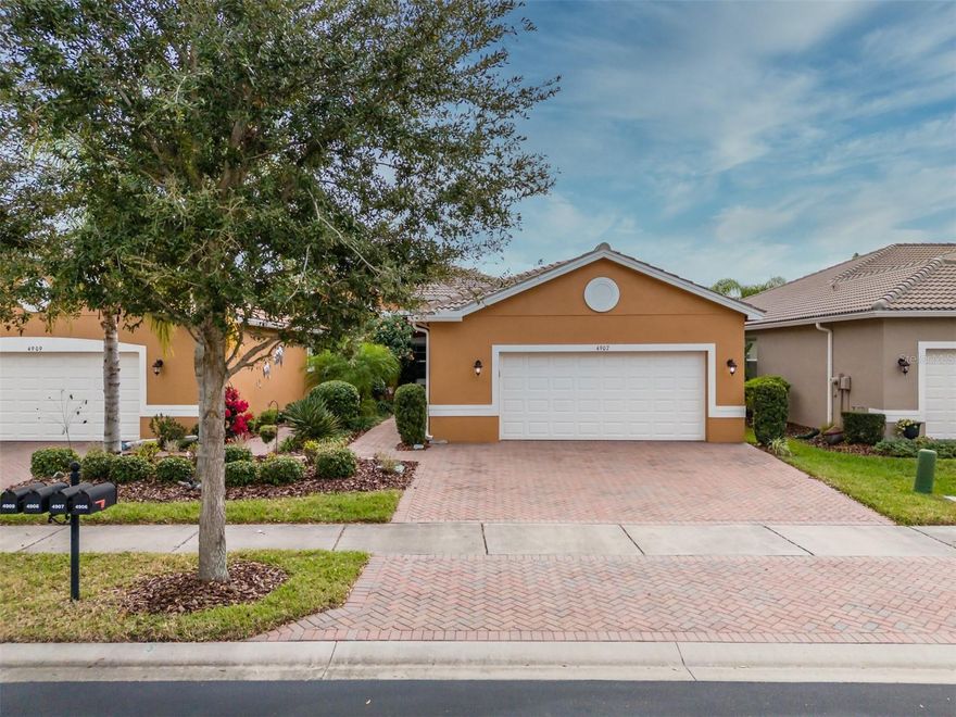 Welcome to Valencia Lakes, Tampa Bay’s premier 55+ Active Adult Community where resort-style living meets everyday comfort. This beautifully upgraded VICTORIA Regal Twin Villa offers 1,710 square feet under air featuring 3 bedrooms, 2 baths, serene privacy, and abundant space to enjoy the idyllic Florida lifestyle. A full width driveway fronts the home. Manicured gardens lead to a covered portico, the perfect space to relax and take in Florida’s natural beauty and year-round pleasant temperatures. Inside, 9.5” x 60” laminate flooring flows seamlessly throughout the home, with tile in the bathrooms.
The gourmet kitchen is a true standout, thoughtfully designed for both form and function. It features solid wood cabinetry with soft-close drawers and doors, two pantry cabinets with pull-out shelving, luxurious granite countertops, a stylish glass backsplash, and a bar-height breakfast counter accented by 3 decorative pendant lights. Samsung S/S appliances include a slide-in range, 3-drawer refrigerator, microwave, & dishwasher. A casual dinette area with an 8’ window creates the ideal space for morning coffee or casual meals. The 13’x12’ dining room is highlighted by a large double window with up & down folded blinds, and it will comfortably accommodate eight. The spacious great room features a Harbor Breeze Saratoga 60” LED lighted ceiling fan and has access through 12’ sliders to the fully screened in lanai. The lanai offers the perfect space to relax, entertain, or simply enjoy the serene water view.
The primary suite, located at the rear of the villa, offers tranquility and privacy with two generous walk-in closets, a Minka-Aire Light Wave ceiling fan, and a well-appointed ensuite bathroom. The ensuite features separated vanities with quartz counters, a large walk-in shower with safety bars, a privacy glass window, and a W/C for the comfort-height commode. 
Bedroom 2, situated at the front of the home, provides exceptional comfort and privacy for guests and includes a lighted Minka-Aire Concept  ceiling fan. Bedroom 3 features double French doors, a built-in closet, a lighted ceiling fan, and will be ideal as a bedroom or home office.  How will you use this space? 
The second bathroom offers a quartz banjo countertop, a comfort-height Sterling toilet, tiled tub/shower, privacy glass window, and porcelain tile flooring. The laundry room is pre-plumbed for a utility sink and includes a front-load Whirlpool washer and dryer on pedestals for added convenience and storage. 
The oversized garage is equally impressive featuring a luxurious epoxy floor, wall-mounted cabinetry, two overhead storage racks, an insulated garage door, and a belt-drive Lift Master opener with MyQ technology. The garage is also pre-plumbed for a water softener.
Additional features include a Goodman HVAC system, hot water heater, and a 200-amp electrical panel, ensuring comfort and reliability.
Valencia Lakes is a true world-class community featuring a 40,000SF Clubhouse, a 5,000SF State of the Heart Gym, 2 Multi-purpose Exercise Rooms, a Resort-style Pool, Resistance Pool, Spa, 5-Lane Lap Pool, Steam Baths, Saunas, 7 Pickleball Courts, 6 USTA Har-Tru Tennis Courts, 4 Bocce Lanes, 4 Shuffleboard lanes, Half-Court Basketball, the best Softball Stadium in the local area, a Dog Park, Garden Plots for the Green Thumbs, over 100 clubs and a Memorial Circle in honor of those who have served.
Seize the day and make your dreams, your reality.