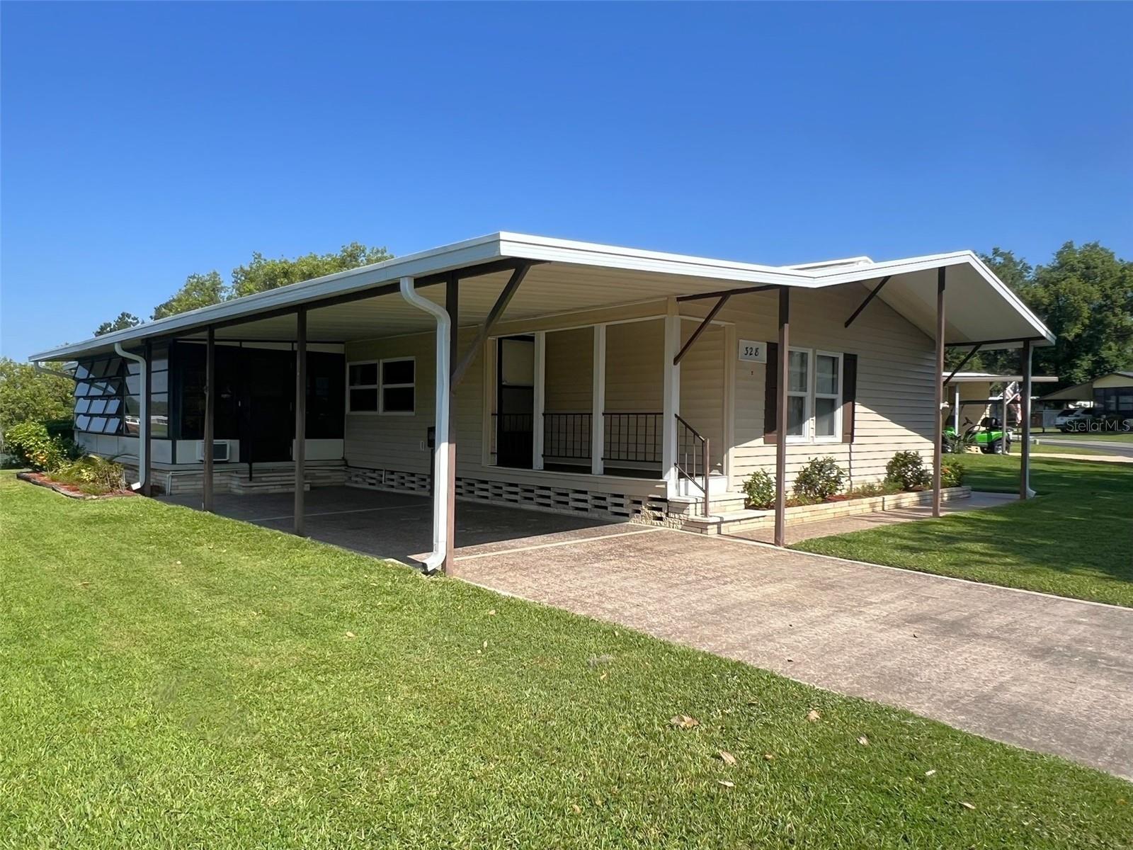 This spacious, WATERFRONT, move-in ready 2 Bedroom, 2 Bathroom manufactured home in the 55+ Floral Lakes Community in Bartow, Florida features double pane windows; new plumbing & lighting fixtures; a large galley Kitchen with closet pantry, ample storage & breakfast bar; a Dining area with built in cabinetry and hutch; a large Living Room and enclosed Florida Room, with access to the rear screened and covered porch; plus a bonus built-in desk/work area just off the kitchen. In this split bedroom plan, the Primary Bedroom features walk-in closet and en-suite bathroom with garden tub, separate shower stall with glass door, and large vanity. Bedroom 2 features a walk-in closet. Guest bathroom features a tub/shower. Carpet and NEW luxury vinyl flooring throughout the home, on new subfloor. Full size washer and dryer (included) are located in the utility room off the rear porch. The (3) exterior doors in this floorplan allow ease of access in and out of the home. Outdoor storage/workshop; single car carport, plus covered and screened patio for outdoor living. A dock could be added with prior approval.
Located in central Florida, between Tampa and Orlando, this golf cart friendly community is near the Bartow Civic Center, Bartow Public Library, and Mary Holland Park. Here you OWN YOUR LAND (no lot rent) and pay low monthly HOA fees. The Floral Lakes community offers access to a stocked pond with community boat ramp and dock. Clubhouse amenities include recreation space, shuffleboard, putting green, and large heated swimming pool. Social clubs, dances, exercise, pot lucks, and MORE! Association approval is required for purchase. Call your Realtor today for more information and to schedule a showing!