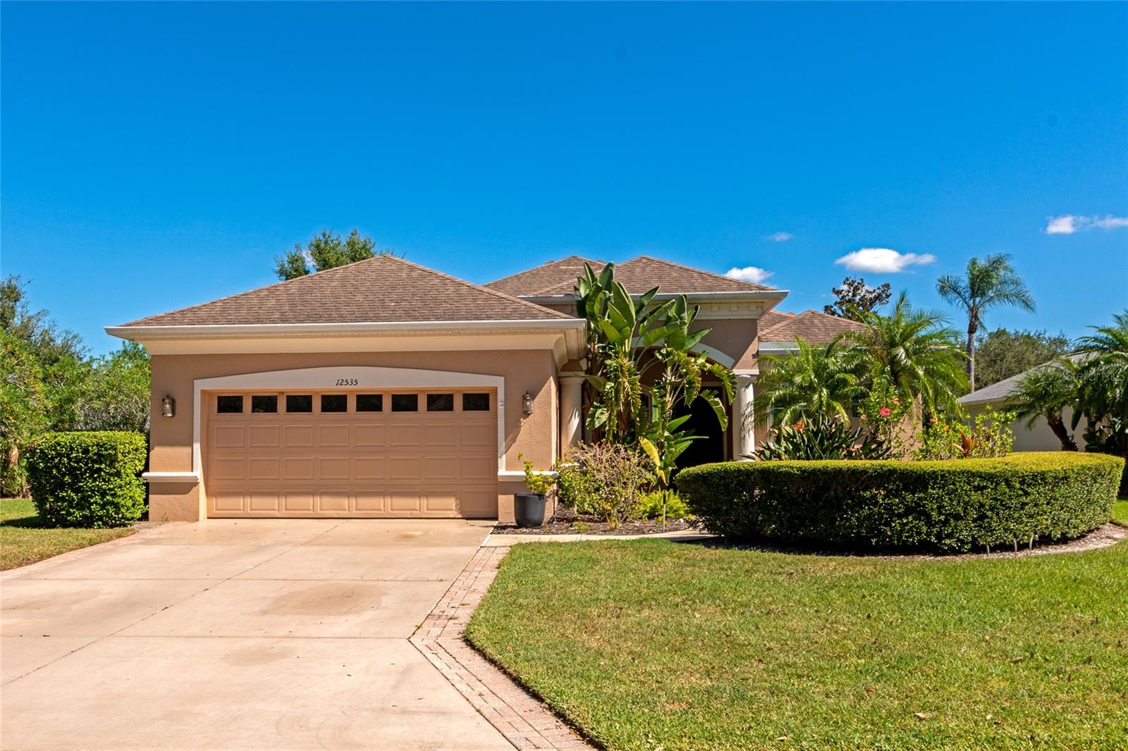 Nestled within the private, gated community of Greyhawk Landing, this spacious 4 bedroom, 3 bathroom POOL home is situated on an oversized lot. As you enter your new home, you'll notice it was designed with entertaining in mind, the open-concept kitchen flows seamlessly into the family room and features granite countertops, stainless steal appliances - including a gas range, a breakfast bar and a cozy breakfast nook with a large window overlooking the tranquility of the pool and pond. The family room features a beautiful custom tray coffered ceiling, and sliding doors leading to the pool in the enclosed lanai. Designed with a split bedroom floor plan for added privacy, the master suite features direct access to the lanai, and an en-suite bathroom with dual sinks, garden tub and walk-in shower. Three additional generously sized bedrooms, all featuring walk-in-closets, are conveniently located on the other side of the home. Two bedrooms share a Jack-And-Jill style bathroom access while the third guest bedroom is more private and offers it's own bathroom that grants access to the pool. An outdoor kitchen space is ready for a new breathe of life and and you may even be indulge in connecting the outdoor shower for maximum tropical living. Once you've unpacked your boxes, you'll want to explore - and luckily, the neighborhood is just as inviting as the home. Greyhawk Landing is a gated, private community just outside of Lakewood Ranch. It features two lagoon style pools, fitness center, clubhouse, tennis courts, basketball courts, soccer/baseball fields, walking and biking trails, playgrounds, and plenty of green space. Outside of the gates, you'll be happy to know that you have quick access to shopping, dining, schools, I-75 and much more! We're excited to show you around - Book your Private Tour Today!