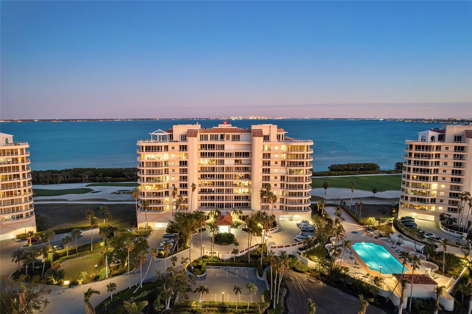 Be whisked to the 9th floor for fantastic views of Sarasota. This expansive, almost 3,000 SF condominium makes a statement with the view alone. Unlike a direct gulf view that turns black at night, this home provides both bay and gulf views. See the city lights, Ringling Bridge and even John Ringling’s mansion across the bay. If a gulf view is preferred, this home has that as well. All of the living areas feature floor to ceiling windows. Need some fresh air? Take in the sun’s rays while basking on your wrap around balcony with nearly 650 SF of space. Awaken to the sunrise in your primary suite and open the doors for access to greet the day from the large patio. This room features a true spa-like ensuite bath, which features two water closets, a garden tub, and glass enclosed shower. There is plenty of room in the spacious primary closet hidden behind the mirrored wall in the bathroom. The secondary bedroom has a walk-in closet and ensuite bath as well as its own balcony. The third bedroom, currently used as an office, also has its own ensuite bath. The kitchen is full of light at the heart of the home and provides access to the dining patio as well as an eat-in dining space and upgraded appliances including a newer sub-zero refrigerator. Mechanically, the home features dual AC units, a large water heater and large laundry room and service entrance. Grand Bay features two large swimming pools, tennis courts, clubhouse, 24 hour guarded gate and membership to the private Bay Isles Beach Club. Deeded beach access is close by, as is shopping and world-renowned restaurants. Membership to the Longboat Key Club and use the adjacent Harborside golf course are always an option.
