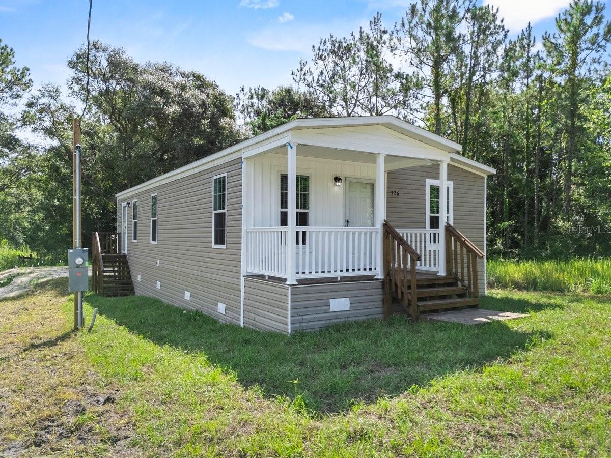 Pre-Construction. To be built. Welcome to Smith Road, nestled in the heart of Central Florida, Polk City offers a tranquil, small-town atmosphere with easy access to a variety of outdoor adventures and community amenities. Your dream home awaits with this brand-new Bartow model manufactured home, offering 3 bedrooms, 2 bathrooms, and over 1,000 square feet of thoughtfully designed living space. From the moment you arrive, you'll be charmed by the spacious front porch with a board and batten accent wall—a perfect spot to enjoy your morning coffee. Step inside and immediately appreciate the high-quality finishes and attention to detail, from the warm woodgrain vinyl flooring throughout to the open-concept layout that effortlessly connects the living, dining, and kitchen areas—ideal for entertaining. The chef-inspired kitchen is a true highlight, featuring brand-new stainless steel appliances, a sleek 36" European-style range hood, built-in microwave, and a central island with pendant lighting, waterfall-edge countertops, and a breakfast bar. You'll also love the shaker-style cabinets in Ozark Shadow, a barn-door pantry, and ample counter space to prep and cook with ease. The primary bedroom offers a serene retreat, complete with a walk-in closet and a luxurious en-suite bathroom featuring a 60” glass-framed shower and dual 36” vanities with a bank of drawers—perfect for keeping all your essentials organized. Two additional bedrooms provide comfortable space for family or guests, while the second full bathroom includes a 36” vanity and a tub/shower combo, ideal for relaxing at the end of the day. Additional upgrades include a dedicated laundry room, LED recessed lighting, modern pendant lighting, low-E insulated windows, and craftsman-style trim with chair rail detailing. This beautifully designed home offers comfort, style, and functionality in every detail, with no HOA or lot rent! Polk City offers something for everybody, whether you're a nature enthusiasts, you’ll have the General James A. Van Fleet State Trail, or an aviation aficionado, you’ll have the Fantasy of Flight museum, or if you enjoy the seasonal local events, you’ll have the Harvest Holler Corn Maze to attend. Centrally located near many restaurants, an abundance of shopping options, theme parks, and easy access to major highways that make driving to either coast a breeze! Schedule your viewing today and experience the best of Florida living!