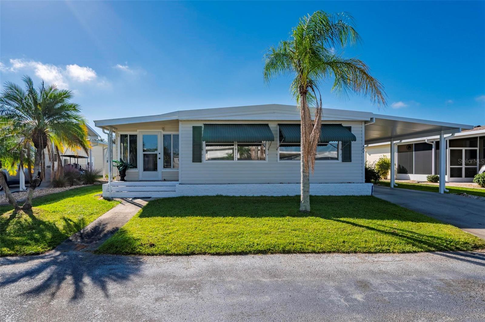 Port Charlotte Village was Voted #1  Manufactured home community in 2024.  Not in a Flood Zone . TURNKEY & BEAUTIFULLY UPDATED! This charming 2-bedroom, 2-bath manufactured home is located in a peaceful cul-de-sac within a desirable 55+ community. Featuring a unique and spacious layout, this home offers exceptional storage and inviting living spaces throughout. The large kitchen stands out with its distinctive epoxy countertops, large double sink, abundant cabinets, and generous pantry—perfect for those who love to cook or entertain. The open dining and living areas provide plenty of room for gatherings, while the enclosed Florida room, connected to central air, offers additional year-round living space. Both bedrooms are impressively large with walk-in closets, and you’ll immediately notice the detailed woodwork on the walls and ceilings that adds warmth and character to every room. Additional upgrades include new vinyl flooring, storm shutters, a brand-new extended carport from December 2023 with ample parking, a roof installed in September 2023, a complete HVAC system from August 2018, and a water heater from 2024. This turnkey home is full of thoughtful touches and ready for you to move right in and start enjoying Florida living at its finest!
