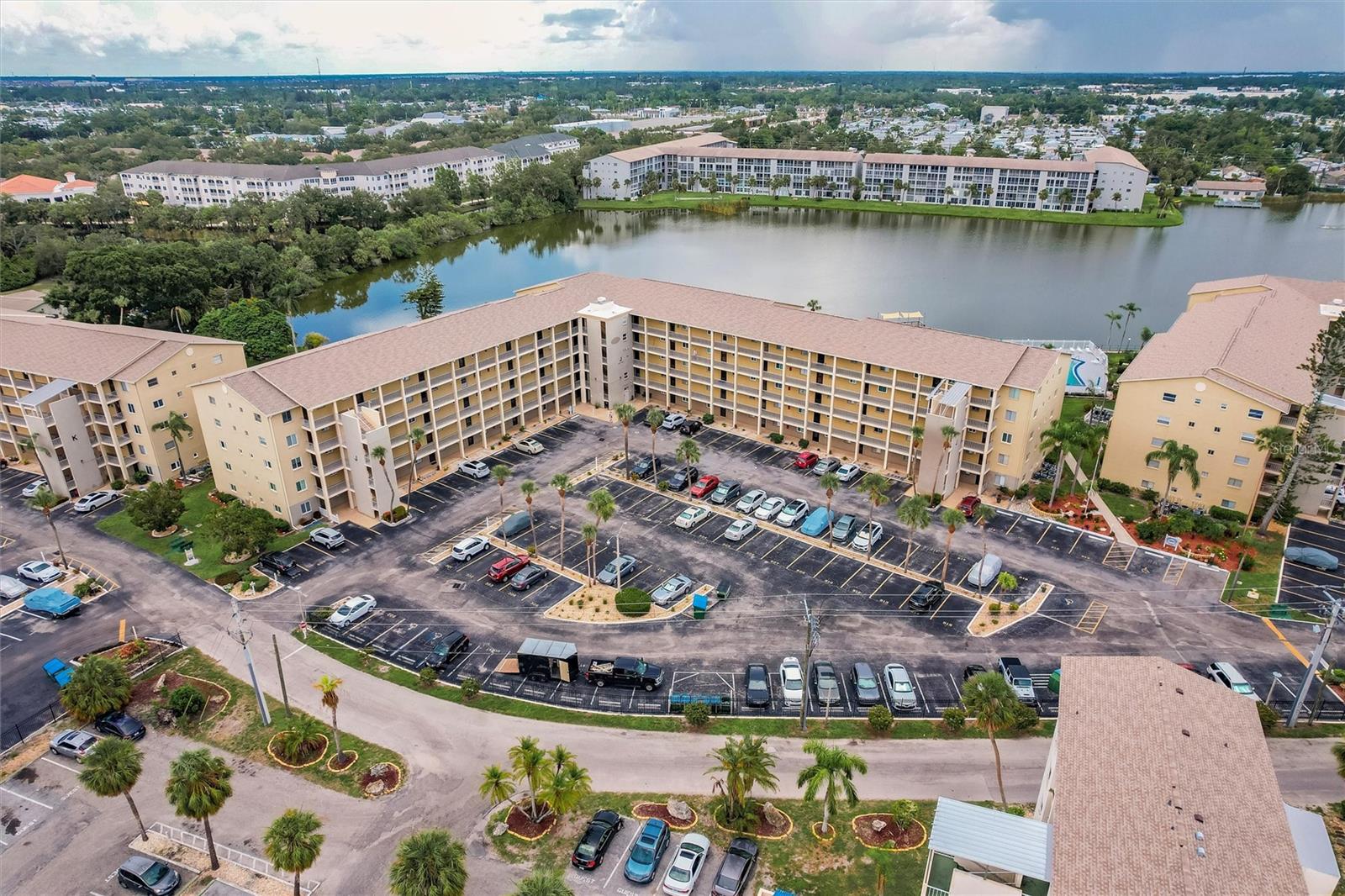 With a panoramic view of the 19-acre Lake Bayshore, this updated 2b/2b, split bedroom plan, is a must-see and priced to sell! It boasts major updates like impact resistant sliders and windows for peace of mind, a newer A/C installed in 2021, and luxury vinyl plank throughout. The light, bright kitchen has recently installed quartz countertops, stainless steel deep sinks and faucet, with updated ceiling and white appliances. The passthrough to the dining room is adorned with a quartz breakfast bar. The spacious dining room/living room combo is flanked by a custom slider leading you to the huge screened balcony from where you can feast your eyes on the morning sunrise over Lake Bayshore. You will also enjoy the lake view from the primary bedroom, which not only has a large walk-in closet but also an ensuite bath and private office nook. Another custom slider provides easy access from the primary bedroom to the private laundry closet on the balcony which houses a newer Samsung washer and dryer and something that is a rarity in most condos – a utility sink!!! Both baths have updated vanities and toilets. Modern fans have been installed in the kitchen, living room, both bedrooms and screened balcony. Enjoy a day of fishing from the pier or kayaking on the lake. Talk about LOCATION, LOCATION, LOCATION … in addition to this spectacular view, the unit is located just two doors from the elevator with an assigned parking spot in near the front of the building (see photo) and close to the pool & clubhouse. Bayshore on the Lake is a friendly, amenity rich, active 55+ community in the heart of Bradenton, close to shopping, restaurants, the beaches of Anna Maria Island, downtown Sarasota, UTC Mall, the Ringling Museum, the Asolo Theater and the Manatee Players. Monthly condo fee includes heated pool, clubhouse, shuffleboard, internet, basic cable tv, trash, exterior and grounds maintenance, building insurance, and management company. Sorry no pets except for support animals (condo approval required). All dimensions are approximate. Schedule your private showing today!
