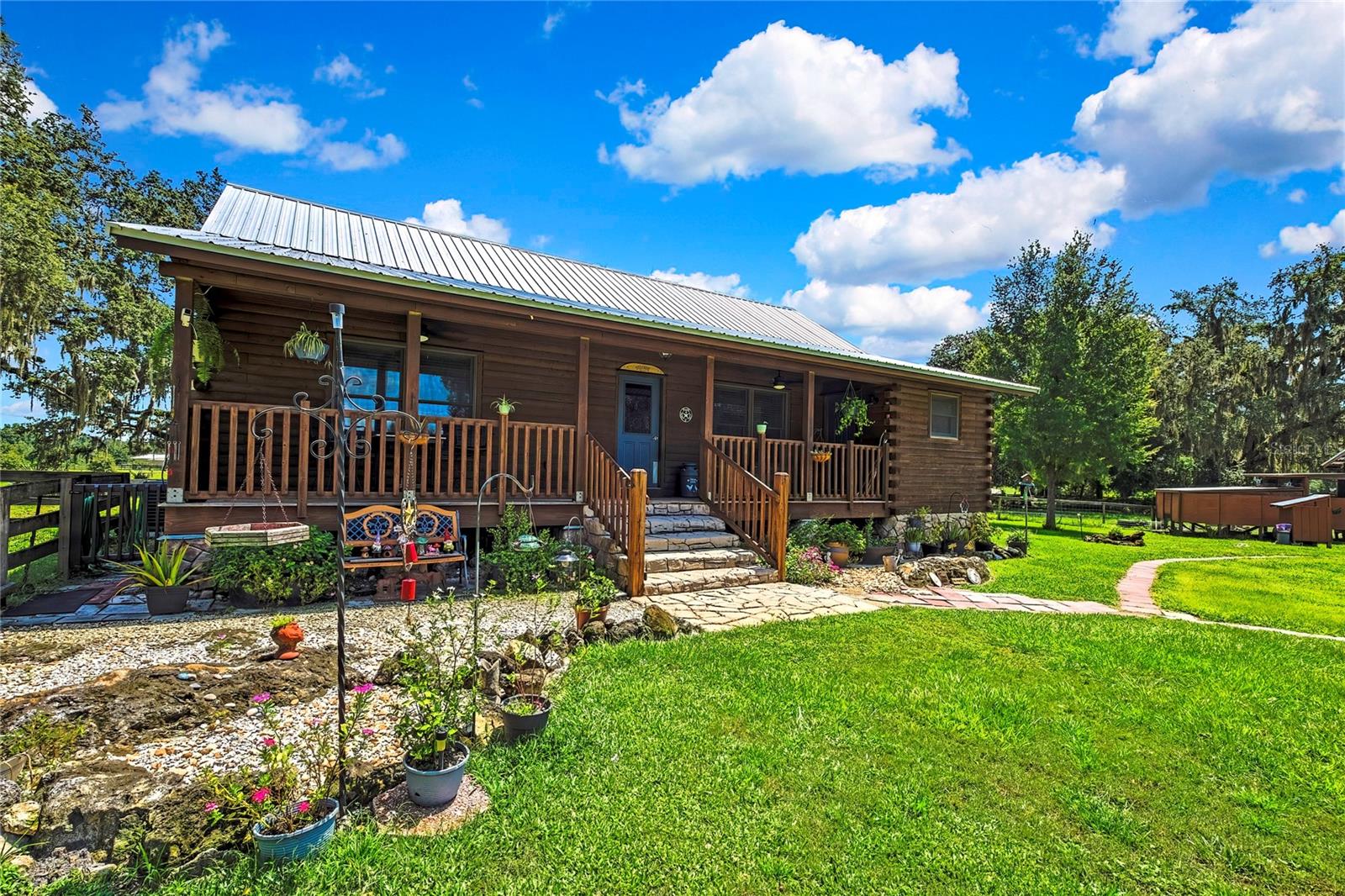 Seller is offering $10,000 to buyer for closing costs or prepaids! Looking for more acerage to homestead? This 6.7 acre parcel located in Bushnell FL, nestled just south of the World Equestrian Center in Ocala. North of Tampa and west of Orlando, is a beautiful horse farm that offers the perfect blend of rustic charm and modern comfort. Tucked away in a secluded, mossy oak tree-lined setting, sets high-and-dry, this property is not in a flood zone and is ideal for those seeking peace, privacy, and a true florida country lifestyle. The main home is a lovingly crafted log cabin on the outside, with the warm, cozy feel of a true comfort home on the inside. Built and cared for by its current owners for years, the home features 3 bedrooms, 2 bathrooms, and an open welcoming layout perfect for family life and entertaining. Home was recently stained with a fresh coat to last several years to come in July 2025!
Equestrians and homesteaders alike will appreciate the thoughtful layout of the land: several horse stalls, a chicken run that goes from the hen house all the way to the main home through a wire tunnel so no creatures can attack, along with a large RV/hay/horse trailer hangar that provides all the space and functionality you need. An additional ranch hand house or guest quarters that is easy enough to rent if needed since its fully furnished with a kitchette and full bathroom, along with a shed for extra storage, round out this turnkey farm.
Whether you are looking to raise animals, ride, or simply enjoy the serenity of nature, this property offers it all. Now ready for the next chapter? This much loved home is waiting for someone new to make it theirs. Call today for your private showing of this peaceful, private, piece of paradise!