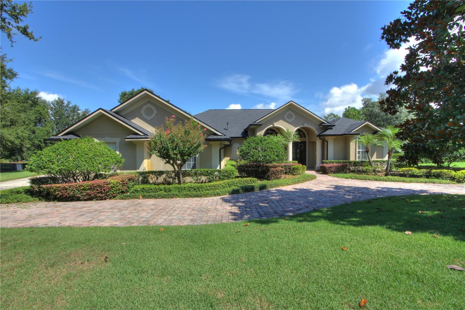 Spacious living for the discerning requirements of the active household with 5 bedrooms all in one floor, large bonus/entertainment room, 3 car garage with deep parking bays, consistent wood and travertine flooring, separate formal living and dining rooms, an expansive rear porch/pool area with covered spaces for seating plus summer kitchen, and a huge 1 acre lot--in Windermere with easy access to Apopka Vineland Rd (minutes from 408/Turnpike, theme parks, entertainment, restaurants, shopping and schools). Practical features such as: propane for cooking, spa heat, water heater, and fireplace; whole house filtration and softener; WiFi-linked pool pump/filtration timer, patio/pool lighting, A/C thermostats, kitchen lights, garage openers, and propane tank level(s); and irrigation with well water. Roof 2023. Bedroom 5/Bathroom 4 may be considered as "In-Law Suite." Community features tennis/pickleball court and playground.