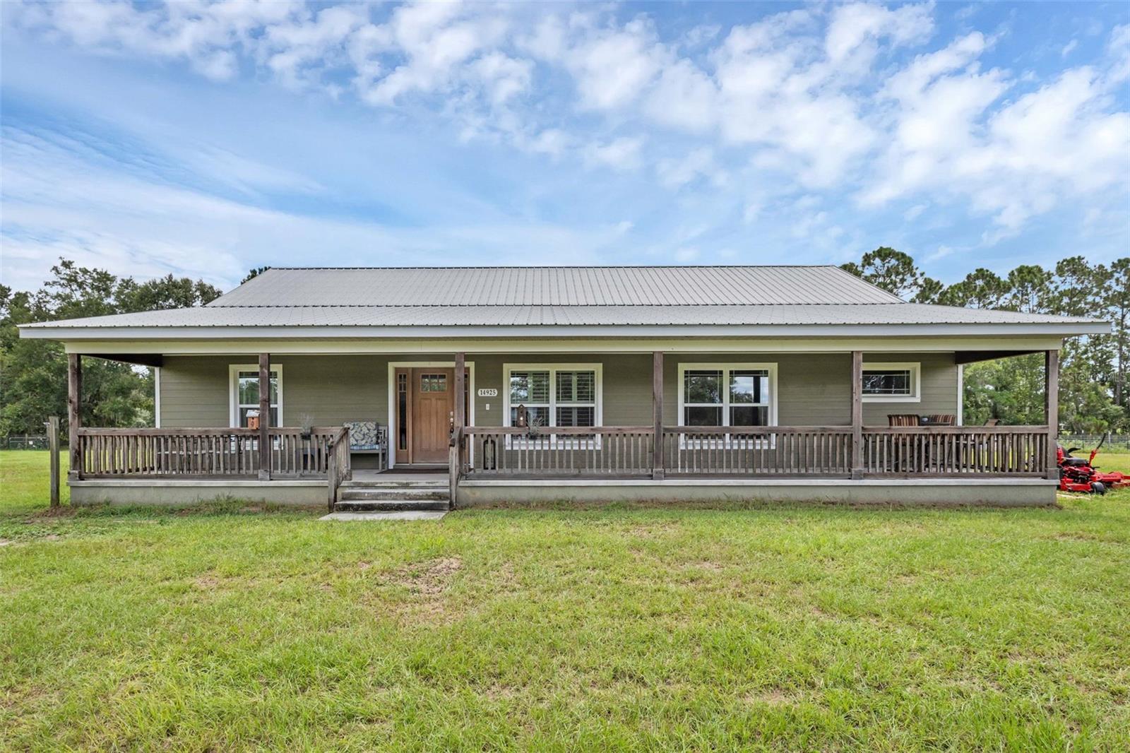 This stunning 4-bedroom, 2-bathroom home sits on 5 ACRES with a FENCED YARD, and blends modern comfort with a warm farmhouse feel, offering the perfect mix of style, privacy, and functionality in the heart of Lake County. With NO HOA, you have the FREEDOM to truly make this property your own—whether that means creating a homestead, adding outdoor structures, or simply enjoying the open space without restrictions.
Built in 2016, this property delivers peace, tranquility, and country living—with SEVEN GATED ACCESS POINTS throughout the land, including an AUTOMATIC GATE at the entry (gates range in size from 6 feet to 16 feet wide) you'll have flexibility for use including animals, vehicles, trailers, etc.
The exterior immediately impresses with a durable METAL ROOF, a welcoming FRONT PORCH perfect for morning coffee, and a SCREENED REAR PORCH ideal for year-round entertaining. FRENCH DOORS from the dining room open directly to this screened patio, creating a seamless indoor-outdoor flow for gatherings, barbecues, or quiet evenings. For those who love outdoor living, the property includes a CHICKEN COOP, outdoor DOG HOUSE, and PLAYGROUND—all included for your enjoyment or homesteading needs.
Inside, the thoughtfully designed SPLIT FLOOR PLAN offers privacy for all 4 bedrooms. The main living space features tall ceilings with exposed beams, recessed lighting, updated fixtures, and an open-concept layout perfect for both entertaining and everyday living. Plantation shutters in the living room and primary bedroom add elegance, while rich-toned flooring throughout creates a warm, inviting feel—and with NO CARPET anywhere, cleaning is a breeze.
The CHEF'S KITCHEN is equipped with granite countertops, solid wood cabinets, stainless steel appliances, a large island, and abundant workspace for cooking and entertaining.
The seller also recently installed a NEW WATER HEATER, and the WASHER AND DRYER ARE INCLUDED, making move-in easy and worry-free.
One of the home’s standout upgrades is the IRON BREAKER WATER FILTRATION SYSTEM with automatic backwash cleaner, offering maintenance-free, WHOLE-HOME FILTRATION. Not only does this mean cleaner, better-tasting water, but it also helps your appliances last longer and run more efficiently.
The primary suite is a private retreat, featuring a tray ceiling, custom barn door entry to the ensuite bath, dual granite vanities separated by a makeup area, a massive walk-in shower with two shower heads, and a spacious CUSTOMIZED WALK-IN CLOSET with abundant storage.
The INSIDE UTILITY ROOM offers even more convenience with added cabinets for storage, granite countertops, a wash sink, and the included washer and dryer, making laundry tasks easier and more organized.
This expansive, 5 ACRE HOMESTEAD offers endless possibilities for recreation, gardening, animals, or simply enjoying the peace of rural living—all while still being close to Clermont, Minneola, and just a short drive to Highway 50.
Schedule your private showing today!