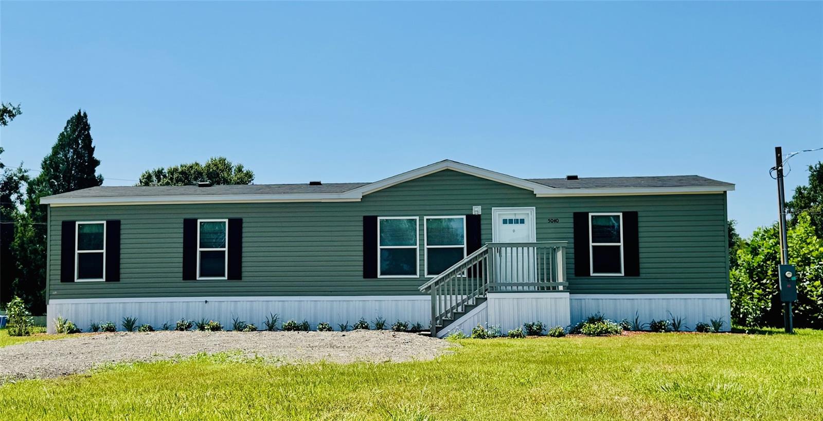 Welcome to your Florida retreat, a place where modern living meets open space and freedom. Nestled on a generous 0.6-acre lot in Lakeland, this brand-new split floor plan manufactured home is the perfect place to put down roots, stretch out, and enjoy life at your own pace. Step inside, and you’re welcomed into a bright, airy space with fresh finishes and modern touches throughout. The open concept living area invites family and friends to gather, while the split bedroom layout gives everyone their own space and privacy. The all new kitchen, with its central island, is the heart of the home where memories are made! Enjoy breakfast chats, baking cookies, or simply gathering around to share stories at the end of the day. The primary suite feels like a peaceful retreat, with a large walk-in closet, and a luxurious ensuite bath where you can relax and recharge. The second and third bedrooms each feature their own walk-in closets, providing plenty of storage space for all your needs. Outside, the property offers endless possibilities: room to build a workshop, park your RV or boat, or start a garden. The septic system has been recently updated for worry-free living. With no HOA, you have the freedom to make this property your own! Located just minutes from Lakeland’s shops, schools, and dining — and with easy access to Tampa, Orlando, Disney, Legoland, and Busch Gardens. It’s the perfect blend of quiet country charm and city convenience, ideal for families, first-time buyers, or snowbirds looking for a low-maintenance base in sunny Central Florida. Come see it for yourself and imagine the life you’ll build here. Welcome home!