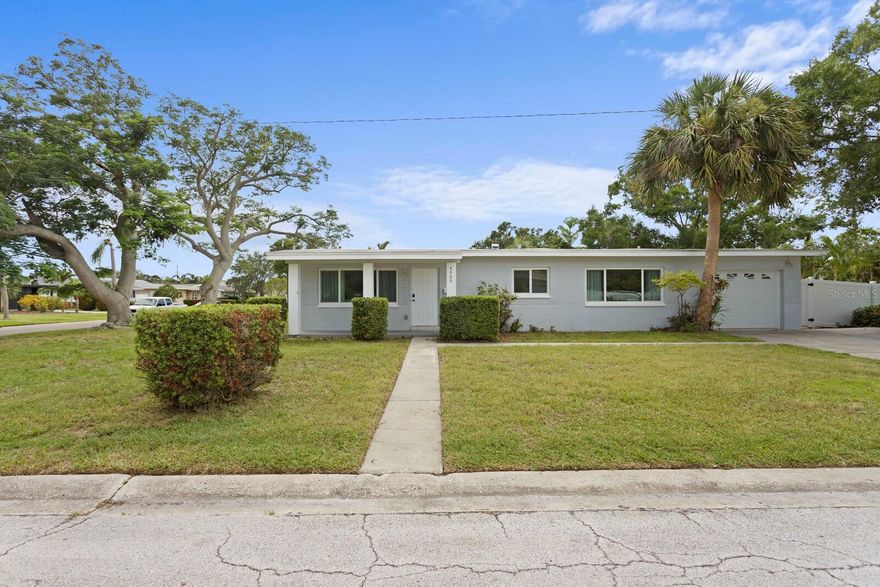This 3-bedroom, 2-bath home with an attached 1-car garage sits on an oversized corner lot in the Snell Shores neighborhood of Northeast St. Petersburg. It offers an open floor plan where the living room flows into the modern kitchen and dining area. The kitchen has bright white-tone cabinetry, generous counter space, abundant storage, with stainless-steel appliances. The split-bedroom layout offers two spacious bedrooms and an updated hall bath with a tub/shower combo on one side of the home. On the other side, a third bedroom with a private en suite bath offers direct access to the backyard and is currently featured as a home office, perfect for remote work or guest stays. The fully fenced backyard offers lots of space with endless possibilities — add a pool, garden, outdoor dining/entertaining space, or even build an accessory dwelling unit (ADU). Notable updates include hurricane-impact windows and a zone-controlled ductless AC system. This dwelling has had no flooding damage from either Milton or Helene. With amenities just minutes away on the 4th Street N corridor, access to Downtown St. Pete is less than 15 minutes, and Tampa International Airport is under 30 minutes away, this location is unbeatable.
