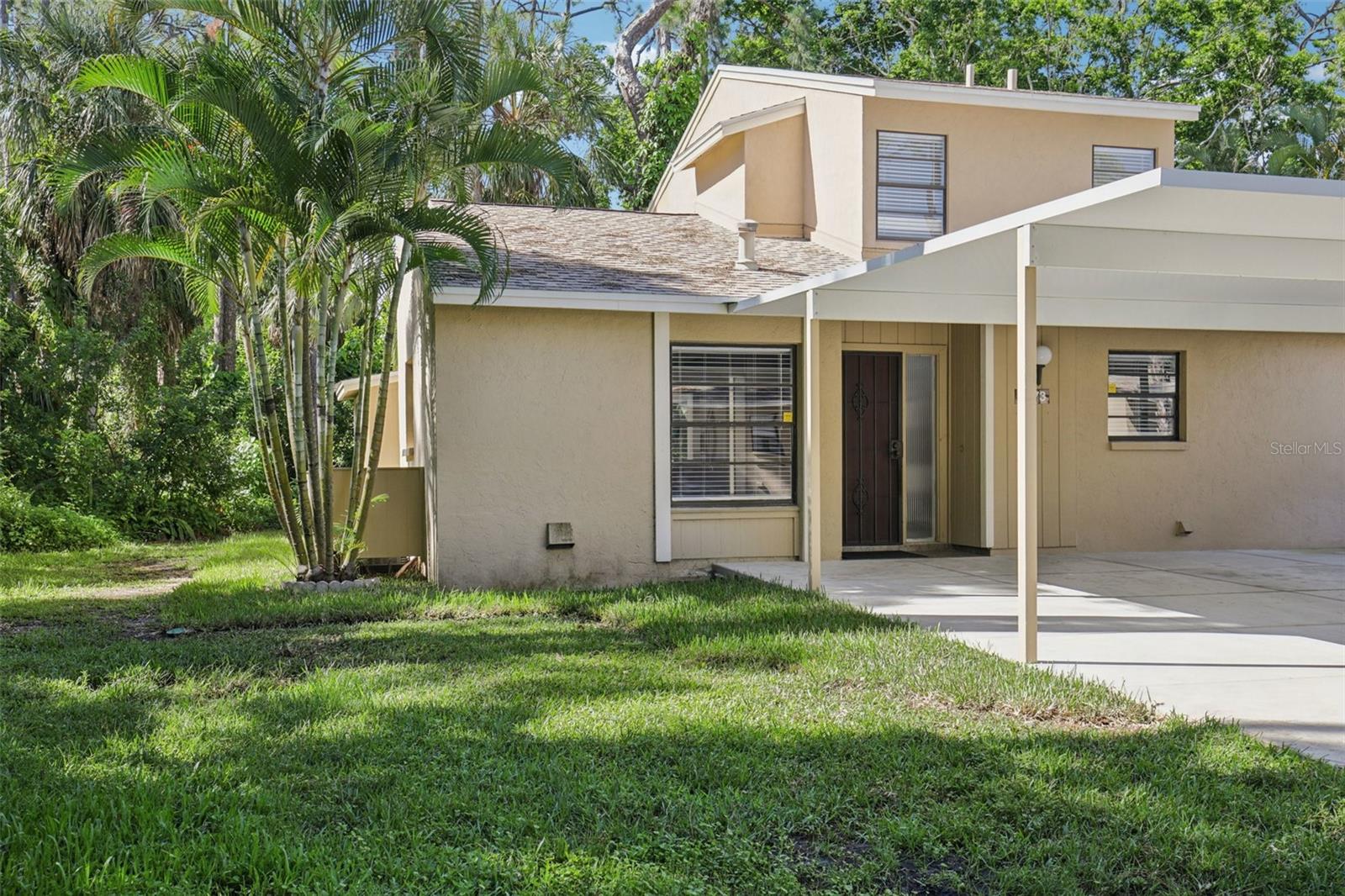 **Back on the market through no fault of the Seller, Buyer's loss is your gain!
Tucked away at the end of a quiet cul-de-sac, this tastefully refurbished two-story “Treetop” villa blends modern living with the natural beauty of Village Gardens. Newly painted in soft neutrals with sleek black accents, and surrounded by stately pines and lush landscaping, this home feels like a contemporary treehouse hidden in the heart of Sarasota.
The first level offers a spacious kitchen with stainless steel appliances and breakfast bar, a bright living/dining room with soaring ceilings and clerestory windows, and an enclosed flex room overlooking peaceful gardens. A guest bedroom and renovated bathroom are conveniently located downstairs, creating a desirable split-bedroom layout. The internal laundry room with bonus under-stair storage adds everyday convenience.  Upstairs, the dedicated owner’s suite features high ceilings, a huge walk-in closet, updated en-suite bath, and its own enclosed lanai with glass sliders—an ideal spot for morning coffee among the treetops.
Extensive updates include new tile flooring throughout, fresh paint, new ceiling fans and lighting, updated bathroom vanities and mirrors, new fixtures and hardware, a new water heater, and a new double carport roof. Every detail has been thoughtfully selected for style, quality, and move-in-ready comfort.
At Village Gardens, neighbors quickly become friends in a welcoming community offering a full array of amenities: heated pool, clubhouse, library, billiards, grill and ramada, tennis, pickleball, and shuffleboard courts, plus an onsite car wash station. This home will appeal to permanent residents, snowbirds and investors seeking long-term rentals. All just minutes from downtown Sarasota, world-class shopping, cultural attractions, and pristine Gulf beaches—this Treetop villa truly checks every box for your Florida lifestyle.