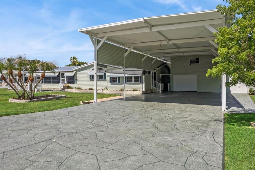 Welcome to this meticulously maintained Homes of Merit manufactured home situated on a rare double lot with beautiful canal views. Major recent upgrades provide immediate peace of mind, including a brand-new roof and a completed foundation upgrade with engineer certification letter already in place.

Designed with the Class A motorcoach lifestyle in mind, this property features an impressive 25’x55’x14’5” RV port with full hookups including 50-amp power, water, and sewer. A custom-painted 25’x75’ double-wide driveway provides exceptional access and maneuverability for even large coaches.

Inside the home, you’ll find a spacious open eat-in kitchen with abundant cabinetry, a 7-foot center island with cooktop, adjoining laundry room/pantry, and a breakfast nook that also functions perfectly as a home office space. The living and dining room combination is enhanced by architectural columns and skylights, while the family room offers attractive laminate flooring and an electric fireplace for added comfort. The enclosed, air-conditioned Florida room is surrounded by windows, filling the space with natural light and providing year-round enjoyment of the peaceful canal setting.

Outdoor living is equally inviting with a covered waterfront deck ideal for morning coffee or evening dining, a rear patio overlooking the canal, and an additional large open patio at the front of the home.

The property’s infrastructure continues to impress with a two-story garage featuring a workshop area and half bath, plus a separate 12’x14’ golf cart shed. Above the garage, an air-conditioned 20’x25’ bonus room with an additional 12’x7’ enclosed storage area provides outstanding flexibility for guests, hobbies, office space, or additional storage.

Beyond the property itself, residents enjoy the lifestyle and amenities of Mount Olive Shores, including the brand-new 5,000-square-foot heated and cooled Community Center featuring a full kitchen, regulation pool and shuffleboard tables, arcade games, card room, library, vending area, and covered BBQ lanai. A full calendar of social activities including bingo, karaoke, holiday events, potlucks, and community gatherings creates a vibrant and welcoming atmosphere.

Conveniently located just minutes from I-4, Mount Olive Shores offers easy access to both Tampa and Orlando, world-class shopping and dining, medical facilities, theme parks, and Florida’s beautiful Gulf and Atlantic coast beaches. Annual HOA dues include lawn maintenance for a truly low-maintenance lifestyle.

Properties offering this combination of upgrades, infrastructure, location, and lifestyle rarely become available. Please note: Mount Olive Shores is a deed-restricted Class A motorcoach community, and ownership or lease of a Class A motorhome is required during the first year of residency.