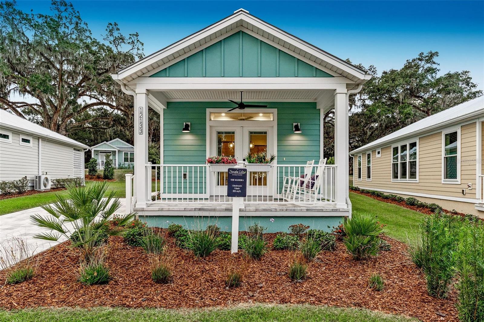 New Construction – Move-In Ready!
Welcome to the Madeira Model, a bright, charming, modern cottage-style home designed with high quality features providing comfort, functionality, and a relaxed lifestyle. This innovative home layout features 1 bedroom and 1 bath, spacious covered front porch, oversized windows throughout, double-sink vanity in bathroom, large bedroom with double closets for storage and an optional side entry off the kitchen.
Located in Lakeshore, a serene Simple Life Community in Oxford, Florida, this home sits on the tranquil shores of Lake Andrew, right on the western edge of The Villages. Lakeshore blends the charm of a hybrid cottage-style community with a mix of site-built and manufactured homes, offering something for everyone.
The community boasts an impressive range of amenities, including: A state-of-the-art clubhouse, Multi-purpose fitness room, Swimming pool and pickleball courts, Scenic walking trails and a fishing pier, Relaxing fire pit and garden area, Dedicated dog park …
Don’t miss this opportunity to own a move-in-ready model in a sought-after location. Schedule your visit today and experience the Lakeshore lifestyle before these homes are gone!