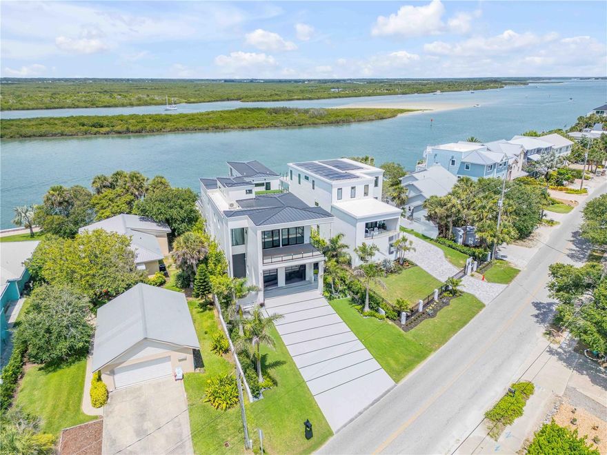 Year 2024 New Construction Where Coastal Elegance Meets Architectural Mastery in New Smyrna Beach. Intracoastal Waterway deep water dock home with modern luxury on an island just a block to the Atlantic Ocean beaches. This extraordinary 5,500-square-foot under air, 5-bedroom, 5-bathroom estate, complemented by 2 half baths, represents the pinnacle of contemporary design and cutting-edge technology. Nestled along the tranquil shores of New Smyrna Beach's famed Intracoastal Waterway, this waterfront mansion offers not just a home, but an experience for the most discerning individuals who seek exclusivity and sophistication. In a rare find for the area, this architectural gem provides direct access to the Atlantic Ocean via 5 minutes by Yacht to Ponce Inlet, ensuring the ultimate coastal living experience in one of Florida’s most coveted seaside destinations. Upon arrival, a towering 12-foot pivot door greets you, hinting at the grandeur that lies within. The home immediately envelops you in a Zen-inspired atmosphere, effortlessly blending tranquility with high-end craftsmanship. As you ascend the stunning 3-story open staircase—each tread an artistic creation illuminated by customizable LED lighting—you’ll appreciate how every detail in this home has been thoughtfully considered to perfection. At its heart is the full integration of Crestron smart home technology, allowing you to control every aspect of your living environment, from the state-of-the-art surround sound system to the artfully designed lighting schemes, all from your mobile device. This seamless technology turns daily living into an exercise in effortless luxury. Spanning three floors, this home exemplifies architectural brilliance. A commercial-grade elevator ensures easy access to all levels, while the first-floor master suite offers convenience, privacy, and a serene retreat. On the second floor, the master suite becomes a sanctuary, complete with an expansive balcony that offers unobstructed views of the deep Intracoastal waters, barrier islands, and beyond. Imagine waking up each day to the serene rhythm of the ocean, with New Smyrna Beach’s white sands just moments away. The third level is a haven for entertaining, featuring a sophisticated bar and entertainment room, which opens to a terrace that boasts one of Florida's most breathtaking sunset panoramas. From this level’s observatory, soak in unrivaled 360-degree views that stretch from the Atlantic Ocean to the Intracoastal, redefining what it means to live on the coast. Outdoors, the luxury continues with an infinity-edge pool that appears to spill seamlessly into the Intracoastal waters, accentuated by striking fire features. The expansive covered deck houses a gourmet outdoor kitchen—perfect for hosting unforgettable soirées under the stars, with the sounds of the ocean as your backdrop. For the yachting enthusiast, a newly installed seawall, private dock, and deep-water boat slip provide direct access to the inlet, offering an easy gateway to the Bahamas and beyond. This exclusive residence is more than just a home; it’s the culmination of over three years of meticulous planning and construction, resulting in a one-of-a-kind masterpiece. With its prime New Smyrna Beach location, offering both direct ocean access and proximity to the town’s charming beaches and seaside atmosphere of many shops and restaurants within minutes of your doorstep. This estate is truly a rare gem.
