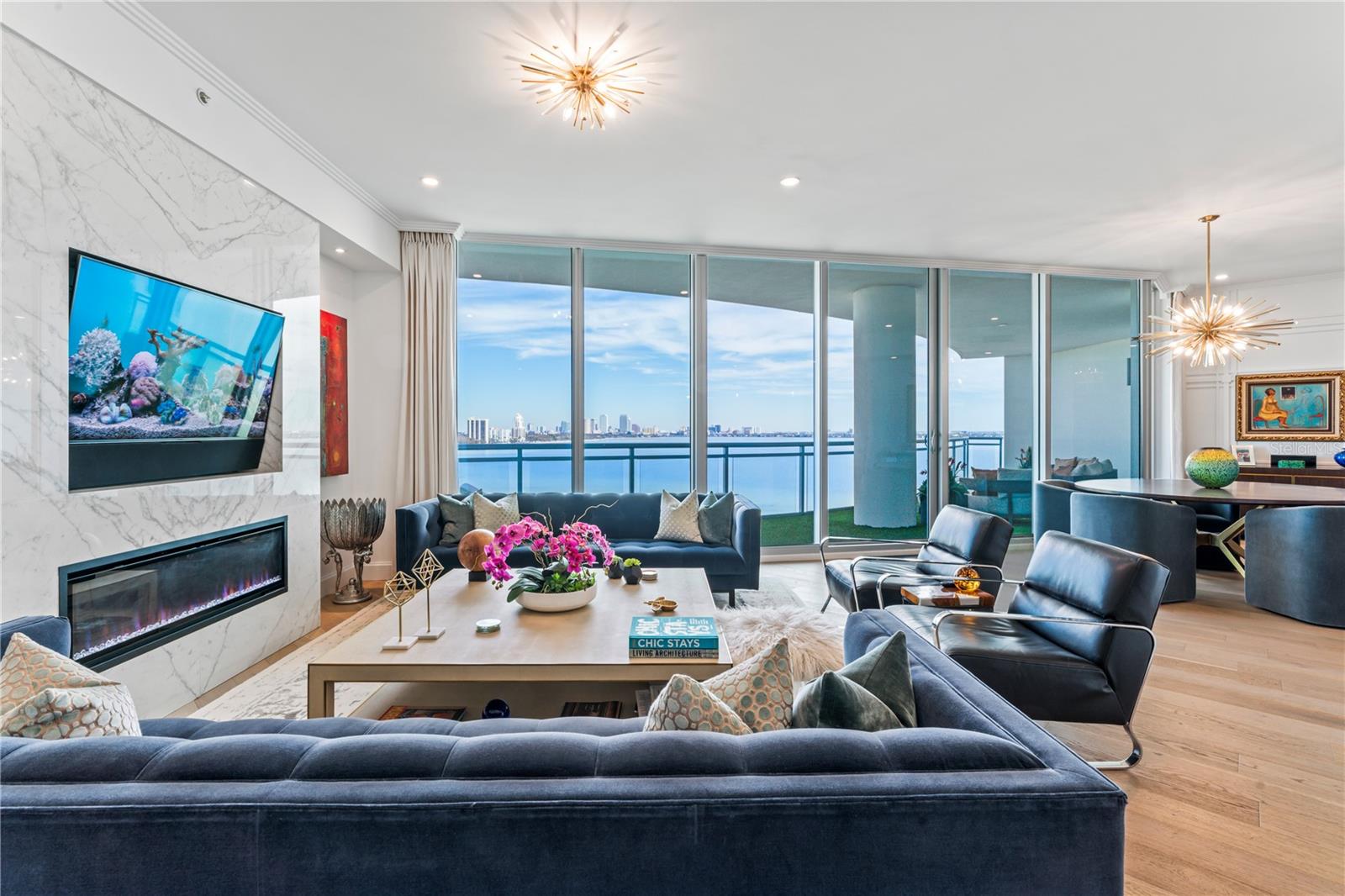 MUST SEE this dreamy stunningly designed condo inspired by the Baccarat Hotel in NYC. The views are absolutely breathtaking with expansive water views framing a picture-perfect postcard view of Downtown Tampa, by far the best view on Bayshore. If you love the daytime views, the nighttime views are even better! Every detail of this home has been painstakingly designed and customized to create a true luxury oasis in the sky. Step off the elevator directly into your private foyer with beautiful black and white geometric tile and notice the uniquely designed millwork with "scorched" wood walls, and a gold leaf ceiling. The home features hardwood flooring throughout, gorgeous custom cabinetry, double thick quartz kitchen island, Wolf Induction Cooktop (wired for gas if you want a gas range), Subzero Refrigerator and all finished off with a beautiful custom marble backsplash. Upgrades are nearly endless in this home and include: built-in electric fireplace with book matched porcelain "marble" slabs, Sonos system with Ghost speakers in the foyer, living, and dining rooms, turf covered oversized balcony, custom electronic voice controlled drapes and lighting, venetian plaster bathroom, wall treatments +++ The Virage is a luxury high-rise featuring 24/7 concierge, pool overlooking Bayshore, spa, grilling area, fire-pit, club room, meeting room, a large gym, massage room, private dog walk, dog spa, bike room, air conditioned storage, and 2 guest suites which can be reserved for your guests. Come live the lifestyle you deserve at the Virage Bayshore!