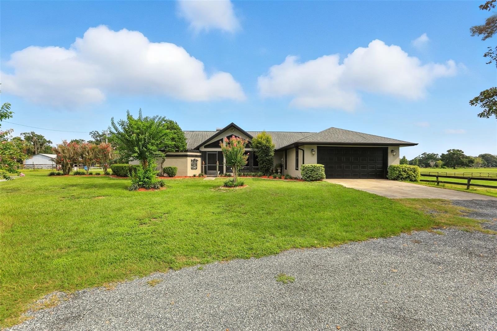 Live the ultimate equestrian lifestyle on this turnkey, nearly 21-acre horse farm, perfectly suited for horse lovers and equestrian entrepreneurs alike. This fully fenced, corner-lot estate is secured with a solar-powered entrance gate and thoughtfully designed for both comfort and business potential.The property features 7 lush pastures, a 10-stall main barn, and a 2-stall foaling barn, making it ideal for breeding, training, boarding, or personal equestrian enjoyment. A full size clay/sand base arena with mirrors for any of your riding needs. A hot-water wash rack, secure fencing, and a well-planned layout streamline daily horse care, while open space allows for future expansion. The 3-bedroom, 2-bath home combines comfort with style, offering a fully screened gorgeous outdoor kitchen and an enclosed half bath by the 8-foot-deep swimming pool—perfect for entertaining or relaxing after a day on the farm. Additional features include a RainSoft water softener systemand thoughtful upgrades throughout, ensuring modern comfort alongside functional farm living. Recently renovated master bathroom, AC unit is only 2 years old. Located just 5 minutes from Majestic Oaks and 30 minutes from the World Equestrian Center, Florida Horse Park, this property balances peaceful country living with proximity to premier equestrian venues, making it a rare opportunity for serious horse owners or aspiring equestrian business owners. Whether you dream of training, breeding, boarding, or simply enjoying the serenity of your own private horse farm, this estate offers the perfect blend of functionality, comfort, and lifestyle—ready to welcome you and your horses-home.