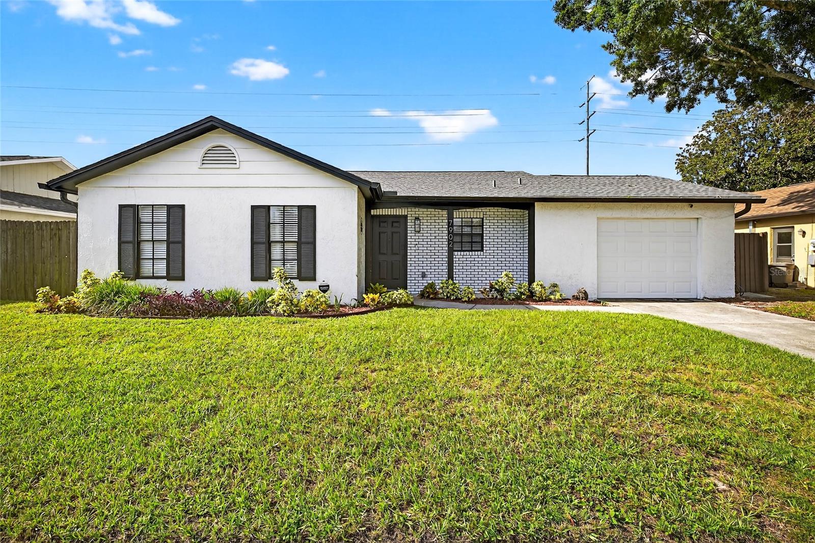Welcome to your beautifully remodeled 2-bedroom, 2-bath home in the desirable Deer Park subdivision of New Port Richey!
This home boasts major updates, including a new roof (2022), a new garage door, and fresh interior and exterior paint. Inside, you’ll find an open-concept layout with luxury vinyl flooring throughout, offering both durability and style.
The modern kitchen features white cabinetry, stainless steel appliances, and a striking custom granite countertop with a waterfall edge—its natural grain flowing over the side like a work of art. A sleek glass cooktop and contemporary stainless steel hood vent seamlessly blend into the space, maintaining an open view to the dining and living areas.
Step out to the screened-in back patio, perfect for relaxing or entertaining, with flexible space for a variety of furniture styles and layouts.
The primary suite is generously sized, accommodating even your largest bedroom set, with space for a home office nook, exercise equipment, or a reading corner. The updated en-suite bath is a luxurious retreat, showcasing a marble tile shower, black fixtures, and a rain shower head, all complemented by an elegant white vanity and large black hexagon tile flooring.
The second bedroom is also spacious—ideal as a guest room or office—and the hall bath continues the sophisticated design, with coordinating marble tile, matching vanity, and black hardware throughout.
Step outside into the fully fenced backyard, a perfect canvas for your dream outdoor space. There’s plenty of room for family gatherings, a future pool, and lush green space with a privacy buffer between you and the rear neighbor.
A spacious 1-car garage provides room for storage or a workshop area, and the laundry setup is conveniently located in the garage without compromising space.
Located just minutes from downtown New Port Richey, you’ll enjoy the newly revitalized Main Street experience, full of shops, restaurants, and parks, including Sims Park and access to the Pithlachascotee River (Cotee River) via the public boat ramp.
Schedule your private showing today and experience the charm and comfort of this thoughtfully renovated home!