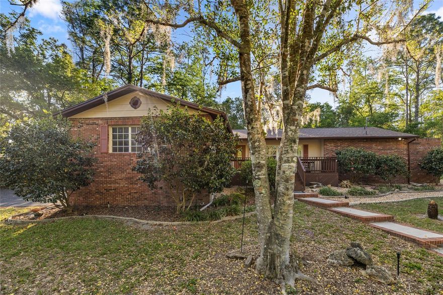 Charming country home full of character and curb appeal, perfectly situated on a spacious 1.14-acre corner lot in the desirable Rainbow Springs Woodlands community. This split-level home features a 2-car garage on the lower level and a thoughtfully designed 3-bedroom, 2-bath split floor plan above. Step inside to a warm and inviting living room highlighted by a real wood-burning fireplace—perfect for cozy evenings. The home has been extensively updated over the years, blending classic charm with modern convenience. Recent improvements include Low-E thermal pane windows, new laminate flooring throughout, and beautifully updated maple kitchen cabinets paired with stainless steel appliances, including a brand-new refrigerator (2025). Additional upgrades provide peace of mind and added value, such as a new roof (March 2026), new well pump (2024), insulated garage door, gutters, and a whole-house water filtration and softener system. The home has also been freshly painted inside and out, including the master suite, main living areas, and exterior (2025), along with updates to the front deck and wood fencing. Outside, enjoy the expansive yard featuring 14 newly planted azalea bushes (2025), a storage shed, and a freshly redone asphalt driveway (2026). High-speed internet is available, making this home as practical as it is picturesque. Residents of Rainbow Springs Woodlands enjoy a low annual HOA fee and exclusive access to the pristine Rainbow River through a private park and pavilion, along with a community center and restaurant. Conveniently located just minutes from downtown Dunnellon, this move-in-ready home truly checks all the boxes for comfort, style, and location.