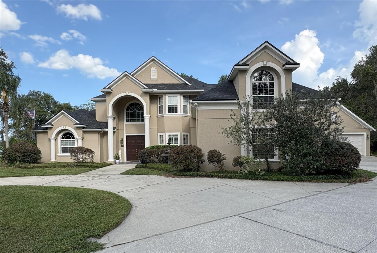 Lake Life at it's best with a 4/4.5 situated on 2.5 acres with direct lake access. This property boasts a spacious open floor plan with a 20 foot ceiling in the great room with a wood burning fireplace and is accented by Brazilian Teak wood flooring throughout the main living rooms with tile on the remaining first floor with crown molding throughout the entire home. The Primary Bedroom is 22x13 with dual closets with expansive views of the lakefront. The open plan has direct views of the lake from many parts of the house along with screened in porches on both 1st and 2nd floors. The home boasts 5 garage spaces with a 2 car garage in the main structure as well as an external 3 car garage with attached outdoor cabana with 1/2 bath giving an excellent venue for entertaining and ample room for all your autos and other vehicles.