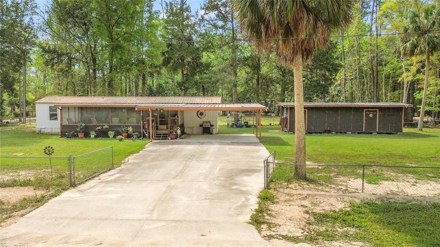 -Fresh air, nature, and a peaceful place to hunt, camp, and enjoy the outdoors found here!- Welcome to 3650 SE 176th Place, a 1.16-acre property with its own move-in ready 2/1.5 single-wide manufactured home, 36x12 workshop with electric, kennel with electric and even more unique storage spaces on-site. Tucked down a well-maintained dirt road and only a few miles from the Gulf of Mexico, this property would make a PERFECT hunting and camping retreat; or an amazing AirBnb opportunity! The 2 bedroom/ 1.5 bath split floor plan single wide has been meticulously cared-for, serving as a primary residence for our sellers. The 32x12 ft. wooden front porch is the quintessential gathering space for morning coffee chats, evening cocktails, and dinners. No mosquitoes here, because it is completely screen-enclosed. We love the concrete parking and covered carport too, for your convenience. Step into the cool AC, admiring the lovely natural light pouring in. The functional open concept living and dining space is ideal. The kitchen overlooks the front porch, and includes a newer Samsung stainless steel refrigerator and stove, pantry closet, and eat-in dining option. To the left, the first of two bedrooms and the full bathroom with step-in tile shower can be found. Washer/ dryer are located in the hallway and convey. The other bedroom with a half bath sits on the opposite side. Out back, enjoy a well-kept wooden deck, hot tub hookup available. Just off of the carport is the huge workshop, a 36x12 room with electric, creating so much storage for your hobbies! Off the back of the workshop, a winterized greenhouse is available to keep plants thriving throughout the year. To the right of the property, find a kennel for your pets, sitting on concrete with electric and water as well. Just beyond the fence line of this residence is an additional .58 acre vacant lot WITH ELECTRIC, WELL, & SEPTIC already in place! This property has 2 more 16x12 storage buildings, currently being used as a wood shop and a 'she' shed. Updates for the single wide: Metal Roof; Water Heater (3 years old); Plumbing Replacement (2 years old); Tie-downs; Septic Pumped in 2025. Forestry/ Rural Residential Zoning. This property comes partially furnished- washer/ dryer, microwave, outdoor patio furniture, wooden dining table and 6 chairs, electric fireplace, and more to convey! This property has endless possibilities- take a side-by-side down nearly 400 miles of dirt trails, or explore the rock quarries; the Coastline is just minutes away. Don't miss the deer, turkeys, and hogs literally in your own backyard! This is such a special place to spend your time- make it yours today! **Seller will provide credit to buyer for first year's flood insurance policy with acceptable offer/ CASH sale.**