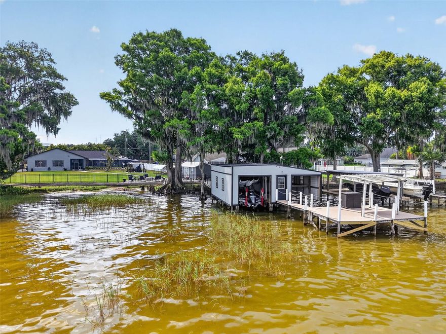 Experience the ultimate Harris Chain lifestyle in this beautifully remodeled lakefront estate with NO HOA. Rest easy with a new roof (2022) and exterior paint.  Boasting over 100 feet of private shoreline on the 7,800-acre Lake Eustis, this 4-bedroom, 4-bathroom residence offers 3,388 square feet of modern amenities designed for both relaxation and grand entertaining. The heart of the home is a gourmet kitchen featuring sleek, soft-close cabinetry, granite countertops, and a high-end stainless appliance package, including a 5-burner gas range and dual ovens.  If that is not enough room the enormous family room has you ready to host everyone on the invite list.  The thought-out floor plan includes two ensuite bedrooms, providing perfect accommodations for guests or a multi-generational setup. Large picture windows throughout the family room, kitchen and dining room frame panoramic lake views and world-class sunsets. Step outside to your private oasis, featuring a sparkling swimming pool and a covered/enclosed boat dock equipped with two hoists. From your backyard, you can cruise to waterfront dining in Tavares, Eustis, or Mount Dora, or spend the day fishing the renowned Harris Chain. Located just minutes from shopping, restaurants, Waterman Hospital and entertainment, this home perfectly blends lakefront living with city convenience.