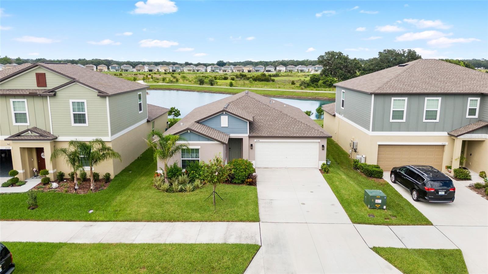 One or more photo(s) has been virtually staged. Waterfront home located at Childers at Two Rivers ... PRIME location ... a few houses away from clubhouse, pool, and playground! This 4 bedroom features a split floor plan. As you drive up notice the upgraded landscaping and garage coach lights! Upon entering there is rectangle tile throughout the main living areas and laundry room. The kitchen opens to the great room and there is a large dining area adjacent to the kitchen ... all have a fabulous view of the pond. The kitchen features dark wood cabinets with quartz counters with a large stainless undermount sink & walk-in pantry. Appliances include convection oven/gas range combo, double door refrigerator, space saver microwave, & dishwasher (all are stainless). The is an Omnipure water filtration system that is included. Sliding doors lead to a covered lanai overlooking the water! The spacious primary suite features a wood raised vanity with dual undermount sinks and quartz counters. The walk-in shower has subway tile and there is a private commode room. There is also an enormous walk-in closet. Hall bath is located between 3 secondary bedrooms. The bath features a raised vanity with quartz counters and undermount sink. The tub/shower combo features attractive subway tile. Both baths have linen closets. All bedrooms and great room have ceiling fans & there is a water softener. The indoor laundry room includes the washer/dryer. The home overlooks a beautiful pond, walking trails, and then another pond ... prime location!! The tankless water heater is a Rinnai. Childers at Two Rivers features a clubhouse, pool, playground, and walking trails. Conveniently located to shopping at Shops at Wiregrass and Tampa Premium Outlets, numerous restaurants, & hospitals.